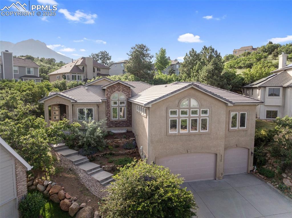 Nestled at the end of a quiet cul-de-sac in the prestigious Northlands at Peregrine, this luxurious 6-bedroom, 5-bath custom-built home offers over 5,000 sq ft of refined living space on a private 0.36-acre lot surrounded by mature trees, scrub oak, city and mountain views. Designed by the original owner with uncompromising quality, the home features soaring vaulted & 10' ceilings throughout, walnut hardwood floors, Berch-brand solid cabinetry, custom trim molding, plantation shutters, and energy-efficient casement windows throughout. The gourmet kitchen is a chef’s dream, showcasing granite countertops, a 5-burner pro gas range, solid walnut cabinetry with pull-out shelving, under-cabinet lighting, & a breakfast bar that seats seven comfortably. A wide hallway leads to a walk-in pantry, main-level laundry, spacious family room, and a full bathroom. French doors open to a versatile flex room with tray ceiling and dual closets, ideal for a guest room or office. The luxurious owner’s suite features a sitting room with a 3-sided fireplace, built-in coffee bar, private walk-out to the deck, & a spa-inspired bath with radiant heat travertine floors, jetted soaking tub, oversized dual-head shower, and a large walk-in closet with custom drawers and shelving. The walk-out basement offers a junior suite with full bath and walk-in closet, a full 2nd kitchen-style wet bar with dishwasher, refrigerator, and wine storage, plus a spacious entertainment area. Additional features include radiant heat floors in all 5 bathrooms, central A/C, 2 furnaces for zoned comfort, 2 water heaters, full-house audio, central vacuum, security system, several storage closets, entire house humidifier & a concrete tile roof. The oversized 3-car garage, Trex deck with built-in gas line, & xeriscaped yard add to the ease of living. Located near top D20 schools, two parks, tennis/pickleball courts, Garden of the Gods, Blodgett Peak, & I-25—this is Colorado living at its finest.
