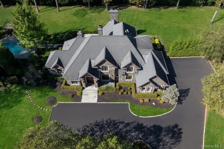 Perfectly situated on over two acres in the heart of Brookville, this stately stone residence combines classic European architecture with modern comfort. Built in 2008 with meticulous attention to detail, the home showcases a full stone exterior with limestone accents and refined finishes throughout. Inside, double entry doors open to a grand interior with soaring ceilings—9 feet on the main level, 8 feet upstairs, and 10 feet in the lower level—enhanced by rich hardwood flooring and Marvin windows. The chef’s kitchen is equipped with Wolf and Sub-Zero appliances, a Bosch dishwasher, Miele coffee system, and custom cabinetry, designed for both entertaining and everyday living. The home features six spacious bedrooms and six and a half bathrooms, including a luxurious primary suite with a spa-inspired bath and generous closets. A car enthusiast’s dream garage offers a lift, electric vehicle readiness, and convenient basement access. The outdoor spaces provide a private retreat with a bluestone patio, heated pool, and gazebo surrounded by lush landscaping. Additional highlights include a 400-amp electrical service, full-house gas generator, six-zone HVAC system, and automated water and temperature monitoring devices. Elegant, functional, and built to last, this home offers an exceptional Brookville lifestyle within the highly regarded Jericho School District.