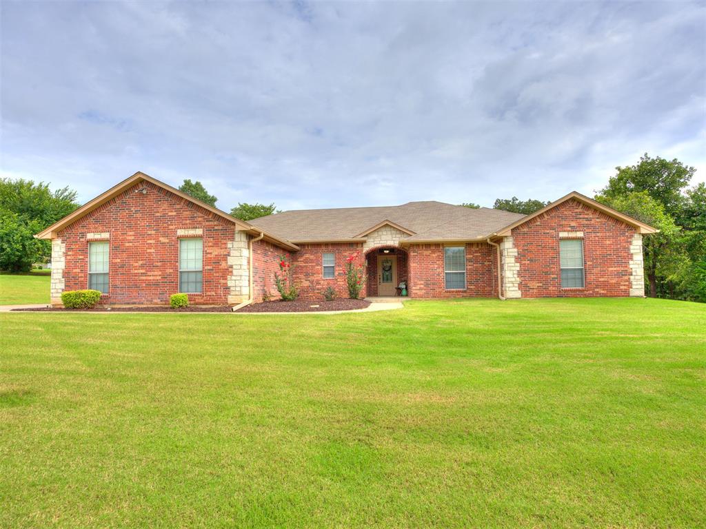 Here you go! A RARE * TRUE 5 BEDROOM * home with 2.5 baths & 3 Car Garage on 1 acre! This gorgeous home with outstanding floor plan is sure to please! Arched entry into living area with brick/stone wood burning fireplace and wood flooring is open to the large dining/kitchen area for an open floor plan! Large windows overlook oversized, covered back patio! Kitchen is a dream with tons of granite counterspace, over & under cabinet lighting, large lighted pantry and SS appliances! Primary bedroom is secluded with tray ceiling, beautiful en-suite bath with black marble shower & tub surround & enormous closet! All 4 secondary bedrooms are good sized with a huge double vanity hall bath. Oversized utility room with storage, folding counter & shelving. Half bath off main living area is perfect for guests! Extended concrete driveway allows for additional/convenient parking outside of the 3 car garage! Storage building remains with property. Sprinkler system front & back & water filter system help tremendously with your maintenance! Heat Pump was replaced in 2024 and Aerobic Septic was just serviced. Enjoy your own private water well! This beautiful, partially treed lot is absolutely gorgeous. Location is just far enough out for country living, yet super convenient to I-35 for metro commuting! Don't miss out on this one! 5 bedrooms is extremely hard to find and SHOPS ARE ALLOWED!!!