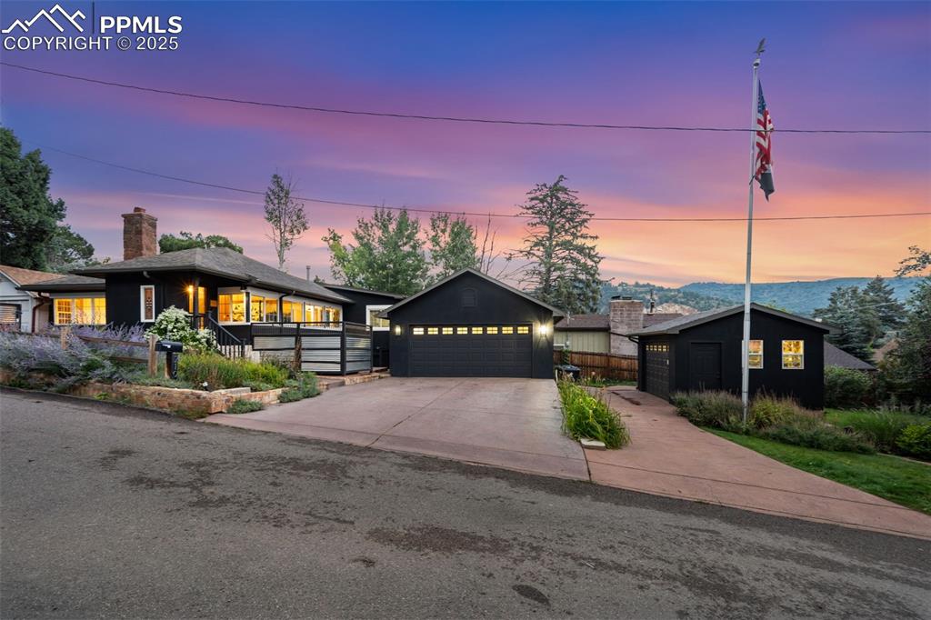 Welcome to this beautifully remodeled mountain home nestled on a large flat lot with stunning mountain views—just minutes from downtown Manitou Springs and the Incline. This unique property offers the perfect blend of Manitou charm and modern updates in a serene, park-like setting.The landscaped lot features mature trees, including a large pear tree, a lighted flagpole, stamped & stained concrete driveways (south-facing for quick snow melt), and vibrant gardens supported by rich, imported topsoil—perfect for green thumbs and outdoor lovers. Enjoy a peaceful retreat while staying close to hiking, dining, and shopping in Manitou Springs. Notable features include: Newer exterior paint, newer roof, stucco, windows, and sewer line, Two-car finished garage with slab floor, Separate garage/workshop with its own electrical panel, 4+ off-street parking spaces, newer hot tub, and Central A/C. Inside, you'll find 5" birch plank hardwood floors, a cozy gas stone fireplace, and a light-filled living and dining area with beamed ceilings and a wall of windows that frame the mountains. The spacious kitchen includes slab granite countertops, hardwood flooring, newer appliances, a pantry, peninsula with bar seating, and ample storage. Step out to the covered patio and discover your private backyard oasis—complete with aspen and apple trees, a pond with waterfall, original rock grill, multiple sitting areas, and automatic irrigation systems. The primary bedroom features a large closet and a vanity nook with views. The remodeled bathroom includes a furniture-style vanity, granite flooring, custom tile, and a skylight. Plumbing for 3/4 bath under the floor of the closet in the second bedroom. The walkout basement offers a flexible non-conforming bedroom—could also be great as a media room or recreation room. With great views, a huge flat yard, multiple garages/workshop, and an unbeatable location, this home is Colorado living at its best!