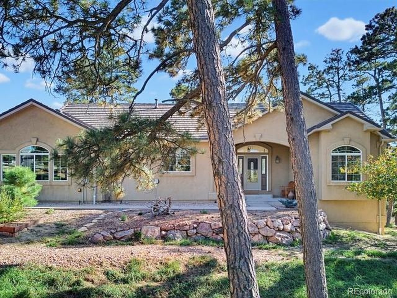 Views! Views! Views! Come see this beautiful, exceptional forested property on over 5 acres with soaring views from allwindows. Enjoy the Colorado lifestyle in this custom, stucco ranch-style home with attached 3-car attached garage and50x30 detached metal garage/shed/barn with 14' door for your RV or up to 12 additional cars. You'll find plenty of room foryour hobbies & pets while you unwind in the pristine Ponderosa forest environment. Discover quiet living here in PeytonPines, in a home that meets all of your needs and more. Situated on a corner lot, this home offers an open floor plan withsoaring vaulted ceilings, gorgeous hardwood floors on the main level, 2 dramatic fireplaces and oversized 33x10 walk-outdeck just off both the main living area and private primary suite. All your storage needs are conveniently provided with anexpansive mud room, and main level office or guest space with adjacent full bath. Downstairs you'll find an enormous familyroom with views & walkout to an expansive patio, 2 additional bedrooms, full bath and storage room that has thoughtfullybeen pre-plumbed to add an additional 4th bathroom, and plenty of room to add a 5th bedroom. Located within 20 minutesof shopping, medical, restaurants and more, you'll find yourself settling into the comfort and tranquility of this specialproperty, with trails, Native American bent trees, cool breezes and whispering pines beckoning you to spend time in natureat your doorstep.