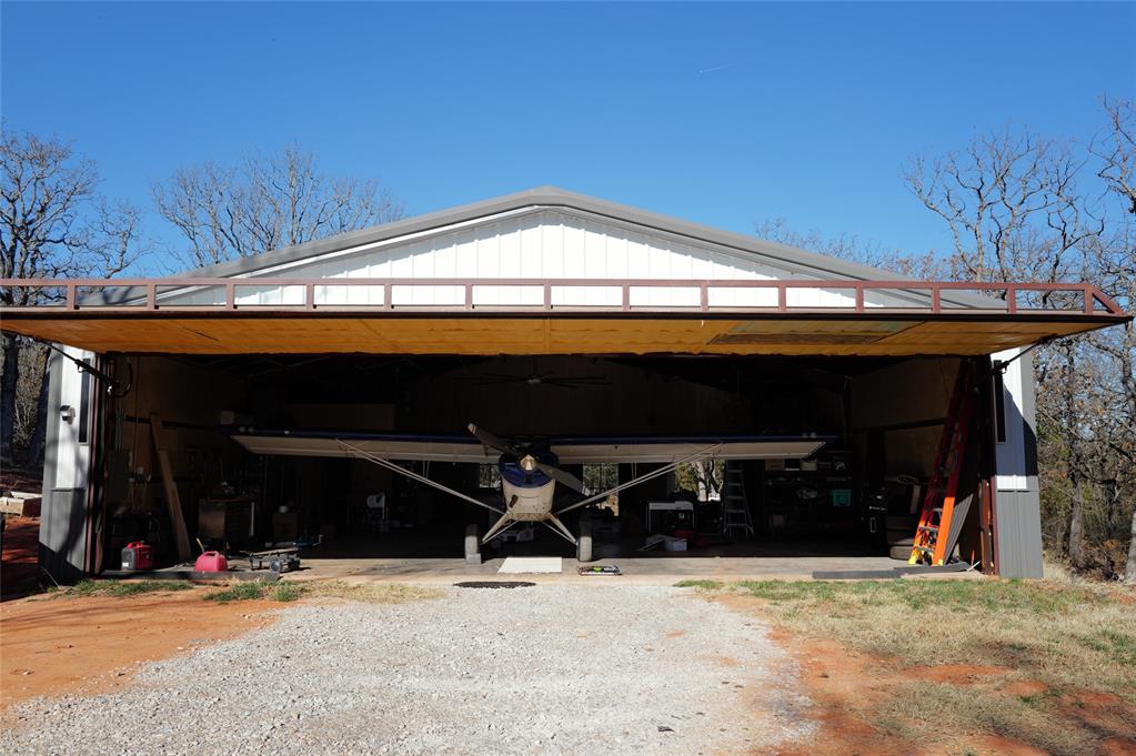 Private 5 acres near Lake Thunderbird, this exceptional hangar home is designed for pilots who want true fly-in living without sacrificing comfort or privacy. The property offers direct access to a private grass runway, allowing you to taxi from your hangar straight to takeoff.The approximately 2,000 square foot hangar residence includes a full kitchen and bathroom, creating a functional and comfortable space ideal for full-time living, a weekend base, or a personal aviation retreat. Solar panels support off-grid living, providing independence and reliability, with no public utilities connected.Surrounded by mature trees, this property delivers the seclusion pilots appreciate, paired with quick access to lake recreation and the Norman area. A rare opportunity to own a fly-in hangar home where your aircraft, lifestyle, and freedom all share the same address.