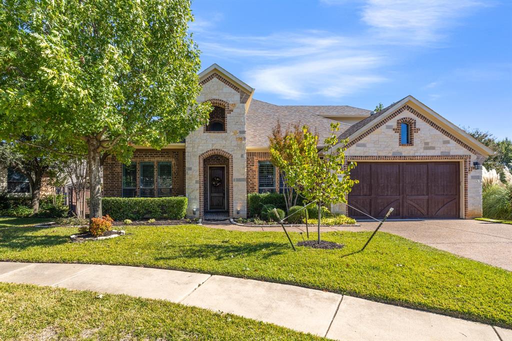 Tucked into a peaceful cul-de-sac at 6005 Valentino Court in the coveted Tuscany Subdivision, this stunning four-bedroom home places you in the vibrant heart of Colleyville—where top-rated schools, premier shopping, and swift highway access (just minutes to DFW Airport) are right at your doorstep. This low-maintenance gem boasts hand-scraped hardwood floors, elegant plantation shutters, updated bathrooms, a stacked stone fireplace, and more. Enter through the welcoming foyer with an adjacent formal dining room and study featuring custom built-ins. The soaring two-story living room flows seamlessly into the chef’s kitchen, complete with a center island, granite countertops, double ovens, gas cooktop, and sunny breakfast nook. The downstairs primary retreat offers dual sinks, a garden tub, oversized seamless shower, and quartz countertops—joined by two additional bedrooms and a full bath, all on the main level. Upstairs, a spacious game room with ample storage pairs perfectly with the bonus fourth bedroom suite, featuring updated LVP flooring and a modern bath. Step outside to your private patio terrace—ideal for morning coffee or evening gatherings—with community green space next door for added breathing room. You can’t beat this prime, central location near restaurants, entertainment, and everything Colleyville has to offer. This is the one you’ve been searching for.