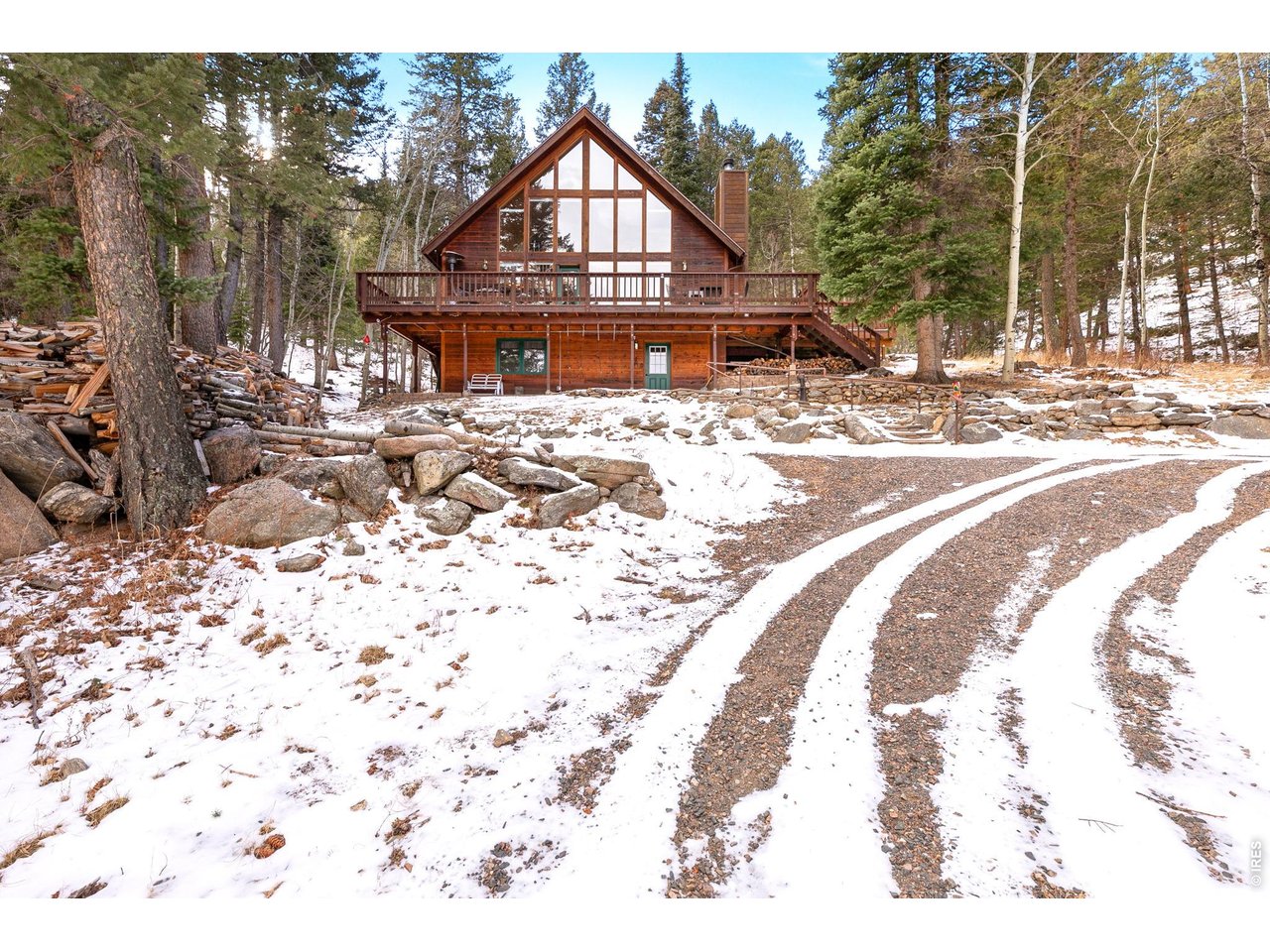 Escape to your own private mountain haven at 1655 Black Squirrel. Nestled in the trees on nearly three secluded acres, this home offers the perfect blend of rustic charm and refined mountain living. The stunning great room anchors the home, featuring soaring tongue-and-groove ceilings, a stone fireplace, and a massive wall of windows that invites the outdoors in. Watch deer wander through the property and listen to the soothing sounds of the seasonal stream right from your living room. Boasting over 2,000 sq. ft. of living space, the home is designed for relaxation. The main level flows effortlessly onto an enlarged deck-perfect for a soak in the hot tub, summer entertaining, or stargazing in the crisp air. The finished lower level expands your options with a spacious gaming area and a private bedroom ideal for family or guests. Located just minutes from Estes Park and the entrance to Rocky Mountain National Park, you also enjoy direct access to the Roosevelt National Forest via the Pierson Park 4WD road. Experience true seclusion with quick access to miles of adventure. Seller indicates all furnishings and furniture may be included in the sale. Come discover the sought-after Little Valley neighborhood.