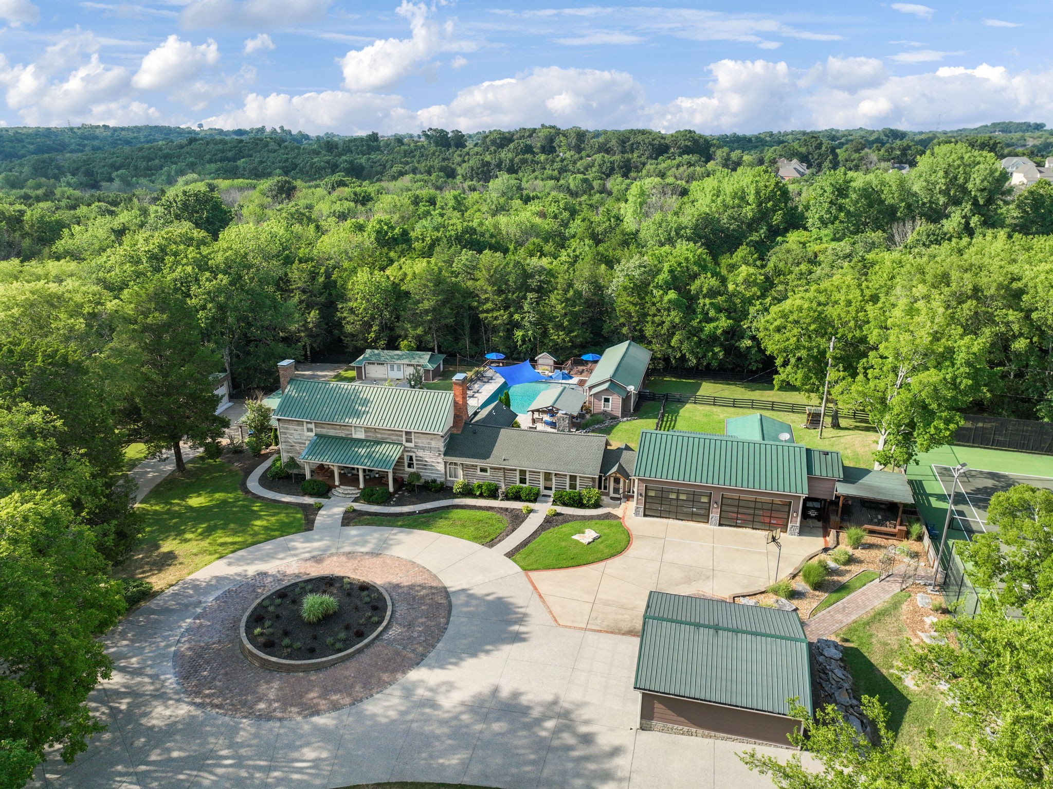 A rare multi-generational retreat spanning approximately 14.6 acres, this private gated estate brings together a beautifully renovated 200-year old log home, two fully equipped guest homes, an additional three bedroom residence, and exceptional resort style amenities, all offered together as one extraordinary property.  Some of the amenities include a U.S Open quality tennis court with lights, a large gunite pool and hot tub with fire features, several outdoor entertaining spaces, attached and detached garages for vehicles or storage, covered carports, large covered boat/RV storage, an enclosed raised garden, a pole barn and a beautiful pond that can be stocked and fished.  The main attached garage at the log house is one that car enthusiasts dream of with huge glass garage doors made for showcasing cars.  It could also serve as a multipurpose space.  It is heated and cooled and features room for a two car lift, has a kitchen, workout room, 1/2 bath with laundry room, and a 2nd floor loft with full bath and walk in closet.  The whole property backs up to wooded Army Corp property.  Less than 5 minutes from multiple boat ramps with access to Percy Priest Lake and a short drive to BNA, Donelson, Mt. Juliet, and downtown Nashville.  This listing consists of multiple properties listed as a whole and will include tax ID Parcel ID/Tax 109-00-0-231.00, Parcel ID/Tax ID 109-00-0-221.00, Parcel ID/Tax ID 109-00-0-140.00, Parcel ID/Tax ID 109-00-0-234.00, Parcel ID/Tax ID 109-00-0-220.00.  Approx 14.6 +/- acres alll together.
