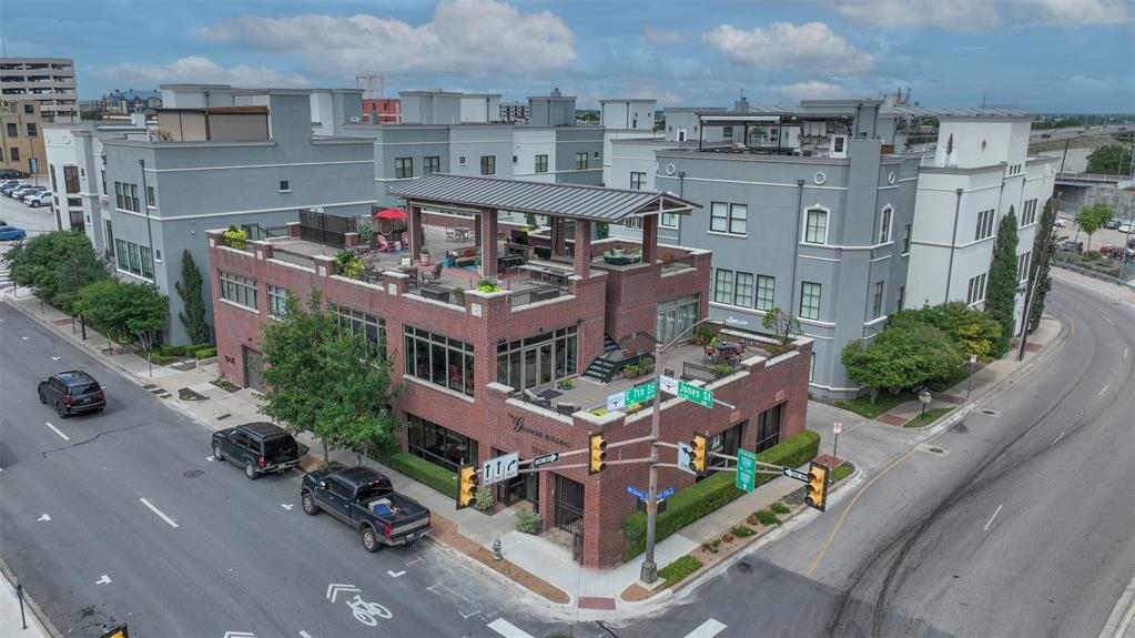 Discover a unique opportunity in the heart of downtown Fort Worth at The Granger Building, offering both commercial office and residential luxury. This meticulously designed two story urban property boasts stunning skyline views and unique, modern finishes throughout. The first floor is zoned for commercial office space, ideal for professionals seeking a prime location. Upstairs, the spacious residential condo features 3 bedrooms, 3 full baths, and one half bath. There are 3 elegant living areas that provide both comfort and style, with an additional space perfect for a study, offering work from home convenience. The open concept layout enhances the contemporary design, with sleek kitchen cabinetry and high end finishes creating a sophisticated, modern feel. Walls of windows provide natural light and striking views from every angle, with custom shades for privacy. Entertain or relax on the expansive rooftop patio with panoramic city views, perfect for enjoying the vibrant Fort Worth skyline. Enjoy entertainment at your fingertips and luxury details throughout. The building also includes a 2 car garage, ensuring convenience in this sought after urban location. This is a rare find where modern living meets business opportunity.