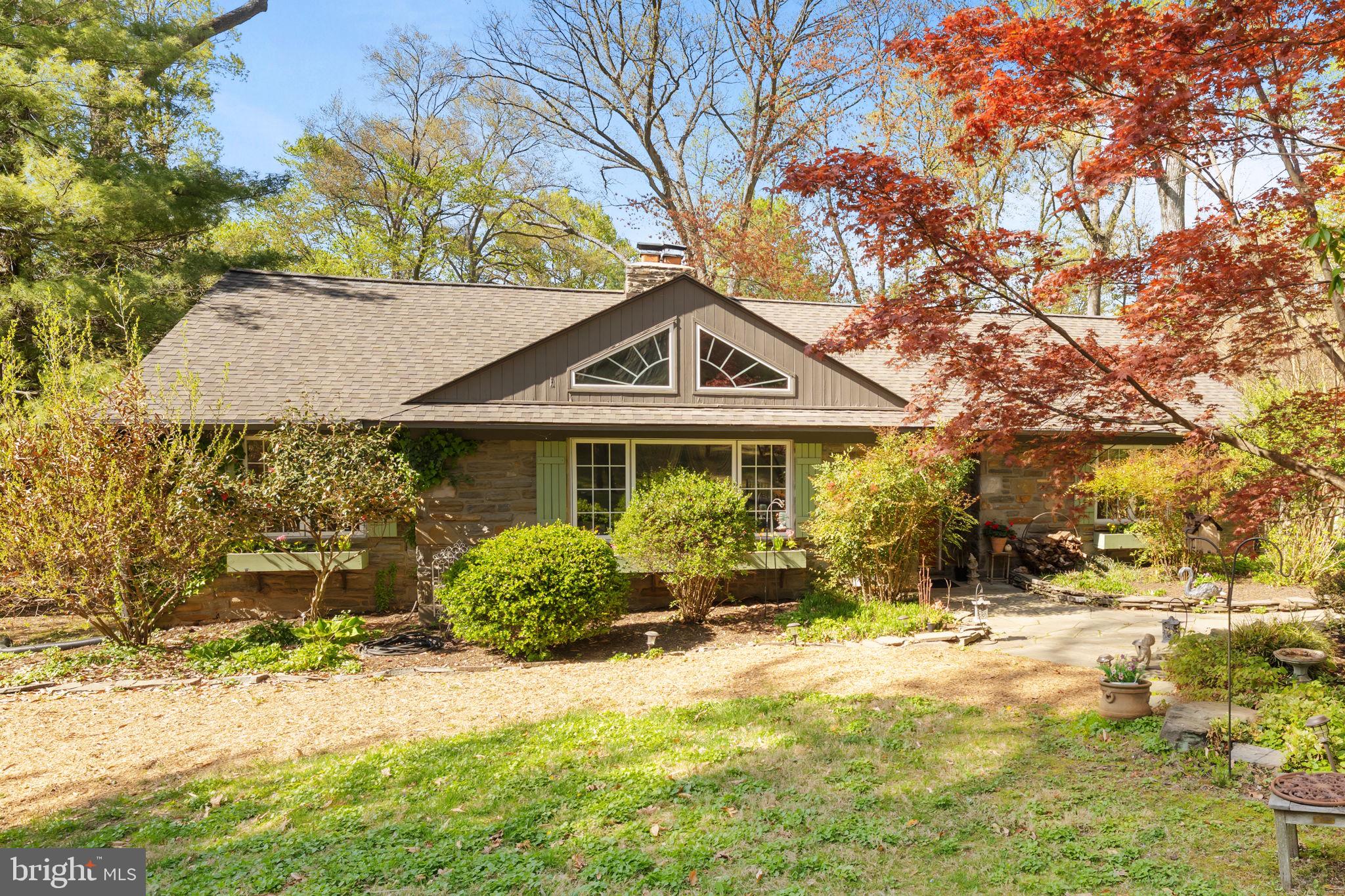 This well constructed and well maintained home, originally built in 1940 and renovated over the years, along with a substantial two floor addition in 1996, epitomizes comfortable and easy living, in a serene setting - The design features a blend of a raised ranch and transitional styles, complemented by quality materials including stone, stucco, and masonry - Spanning over 1.05 acres, the nicely landscaped lot offers a private retreat, with trees, beautiful shrubbery and other thoughtfully selected plantings, with attention to animal resistant plants and low maintenance - The outdoor space is enhanced with hardscaping, providing an ideal backdrop for entertaining or relaxation on the expansive deck and patio - Driveway parking and a two car attached garage - Inside, the main level has three bedrooms and two full bathrooms - The primary bedroom is very large, with double closets, a dressing / sitting / work area and a private bath with shower and separate large jetted tub, with great window views - The other two bedrooms on this level have nice light and closets with organizers - Also on this level, you have a large peninsula kitchen that opens up to a great room with vaulted ceiling that extends to the wrap around deck - There is a custom double door pantry - Almost new Thin Q LG Built in micro / Gas five burner range / French door frig - The great room has reinforced floor framing to accommodate another fireplace too - In the trees views - Fantastic flow  - Nice entertaining space - The last two rooms on this level are the living room with floor to ceiling stone fireplace and built ins, and a very nice dining room - The easy flow here is really noticeable - The lower daylight level has a bedroom with adjacent walk-in closet space, a large separate office and second great room / living room  - Many options here for upscale and private in law accommodations, or guest room,  or home office space, or a recreation room, etc - Many windows throughout most of the space with walkout french doors to a patio - There is a tiled full bath and nice laundry area and a workshop too - The attic has pull down stairs to large, clean and floored storage space - Click Photo to Enlarge - See Virtual Tour Icon - See Floor Plans & measurements at the End of the Photos - Buyer to verify square footage  -  Alarm and camera surveillance for your security and package deliveries, etc ...