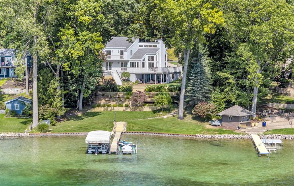 DISCOVER LAKESIDE LUXURY AT FARWELL LAKE! Tucked away at the end of a tranquil cul-de-sac, this exceptional property offers unrivaled privacy and a coveted ''Up North'' setting. This completely updated, modern 3 bedroom, 3 full bath home offers over 2,400 square feet of thoughtfully designed finished living space with 100 feet of private lake frontage & steel seawall. From the moment you step inside, you'll be captivated by soaring vaulted ceilings and an expansive wall of windows framing breathtaking lake views. Cozy up to the natural wood burning fireplace this Fall & Winter season. The open concept main level flows seamlessly into a completely updated kitchen featuring new quartz countertops & appliances with stylish finishes. Main floor living adds convenience and comfort, while the wraparound deck invites you to relax and soak in the scenery. Each of the bedrooms offer lakeside views with private sliding door walkouts & the two bedrooms upstairs share a balcony.The finished walkout lower level features heated floors, a new wet bar & carpet, full bathroom & sprawling additional living room. Enjoy entertaining outdoors with multiple spaces-from the exposed aggregate concrete patio, to the wraparound deck with sunken hot tub and the terraced lakeside deck leading to the cascading steps to the waters edge. The lush 0.65 acre setting includes irrigation systems with multiple zones to covers the entire yard. All new landscaping & a evergreen border of pine trees ensures your privacy remains all year long. Updates include main floor bathroom with tile walk-in shower & glass enclosure, brand new second floor bathroom, all interior doors, sliding glass doors, flooring, paint, fixtures, kitchen, irrigation pump & more. Natural gas whole house auto generator. 2 Car detached garage & concrete drive. Freshly paved roads & Xfinity high speed cable is available at the street. Don't miss your chance to own a piece of Southern Michigan's most desired chain of crystal-clear-Caribbean-blue lakes exploring through Rainbow, Farw