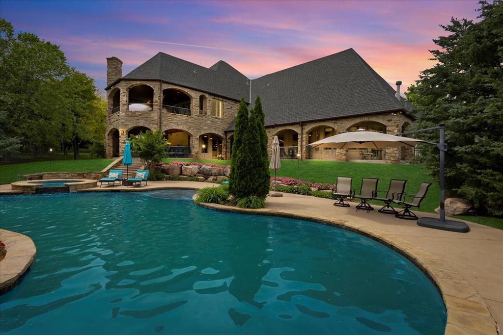 Located in the private, gated community of Edgewater to Edmond, this Edmond-area estate offers a refined blend of country serenity and luxury living, all within minutes of city conveniences. Thoughtfully designed for both comfort and entertainment, this custom-built home sits on a meticulously landscaped lot surrounded by mature trees and open green space, providing a true sense of privacy and connection to nature. Inside, you'll find a spacious, light-filled layout featuring soaring ceilings, wood beams, and designer finishes throughout. The chefs kitchen is equipped with top-tier stainless steel appliances, a Hoshizaki commercial ice maker, oversized island, walk-in pantry, and custom cabinetry perfect for everyday living or entertaining on a larger scale. The main living areas open to multiple covered outdoor living spaces, including an outdoor fireplace, lounge area, and a custom resort-style heated pool with rock waterfall a true centerpiece for gatherings and relaxation. Professionally designed landscaping, ambient lighting, and a full irrigation system elevate the exterior experience. Inside, the home includes a large primary suite with spa-like bathroom, a home theater with 120 screen and built-in surround sound, game room, bonus room, and an executive office suite with custom built-ins. A framed-in shaft allows for the future installation of a residential elevator, making the home ideal for long-term, multi-generational use. Located just minutes from Lake Arcadia, you'll have easy access to boating, fishing, paddleboarding, hiking and biking trails, picnic areas, and family parks. The home is also ideally positioned near major highways, offering quick connections to Edmond schools, dining, shopping, and downtown Oklahoma City. This rare offering combines custom construction, luxury amenities, and a highly desirable locationmaking it one of the most complete and versatile properties available in Edmonds gated luxury market.
