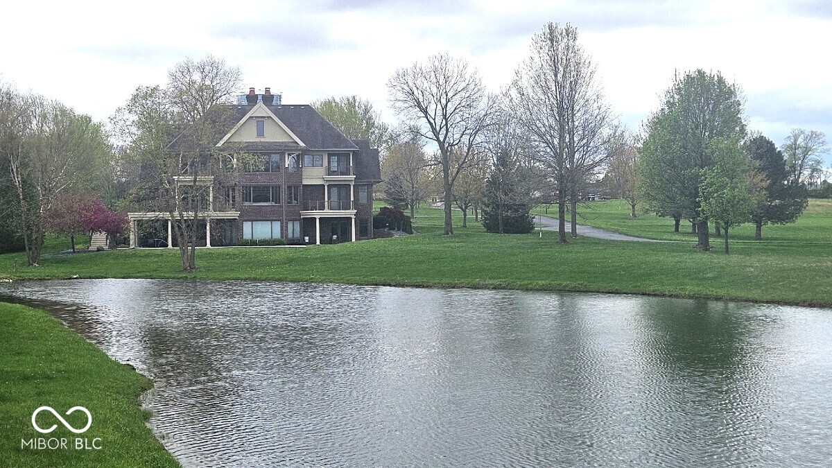 Welcome to this stunning 8,050-square-foot Duke-built estate nestled on 20 breathtaking acres in the heart of Center Grove. Surrounded by mature trees, scenic walking trails, and abundant wildlife, this exceptional property offers unmatched privacy with panoramic views of a private lake and wooded landscape. The home is spacious and elegant, featuring exquisite finishes and thoughtful design throughout. It offers four generously sized bedrooms, each with an on suite bathroom and walk-in closets, ensuring comfort and privacy for all. The grand primary suite is a true sanctuary, complete with a spa-inspired bath, dual vanities, a soaking tub, and direct access to an outdoor terrace overlooking the tranquil water. Entertaining is effortless with multiple living areas, including a stately formal dining room, a cozy fireside great room with soaring ceilings and floor-to-ceiling windows that frame the lush surroundings, and a chef's kitchen equipped with top-of-the-line appliances, custom cabinetry, and an oversized center island. The adjacent breakfast nook and sunlit hearth room offer perfect spots for casual dining and morning coffee. The lower level is designed for recreation and relaxation, featuring a full entertainment suite with a wet bar, home theater, wine room, fitness space, and additional guest suite. Multiple flex spaces on this level provide opportunities for a home office, art studio, or game room. Step outside to your own private retreat with expansive patios, an outdoor kitchen, and serene seating areas overlooking the lake ideal for al fresco dining, sunset gatherings, or simply enjoying peaceful views. The property's beautifully grounds include walking paths, flowering gardens, and mature woodlands that border the shimmering lakefront. This rare offering combines refined luxury, timeless design, and unparalleled privacy just minutes from shops, restaurants, and the top-rated schools that make Center Grove one of the best places to live.