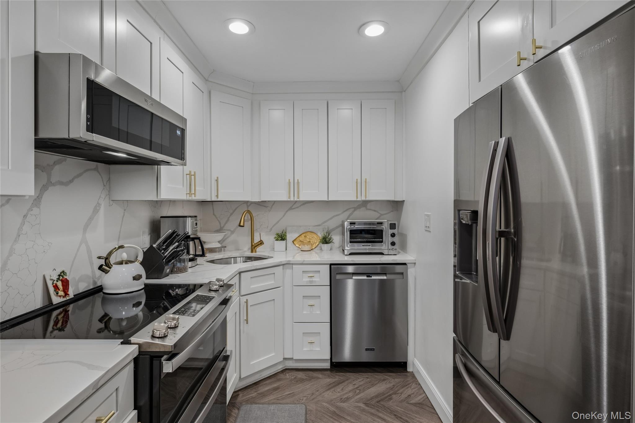 Welcome home to a beautiful, move-in-ready three-bedroom residence where modern finishes meet warm, inviting style. The renovated kitchen is a true standout with crisp shaker cabinetry, luxe gold hardware, sleek quartz counters with dramatic veining, a designer gooseneck faucet, and stainless-steel appliances—perfectly set up for everyday living and effortless entertaining. An open-concept living and dining area is filled with natural light from an expansive wall of windows dressed in airy custom drapery. Rich herringbone floors flow throughout the main living space, while a striking stone accent wall with a linear fireplace creates a sophisticated focal point and a cozy ambiance. Step outside to your private balcony—ideal for morning coffee or unwinding at the end of the day with tranquil views. The home offers comfortable, well-proportioned bedrooms, including a serene primary retreat with generous closet space, plus versatile additional rooms that easily accommodate guests, a home office, or hobby space. The bathroom features timeless tilework and updated fixtures, completing the home’s polished feel. Le Havre amenities include two outdoor pools, three tennis courts, a fitness center, club house/restaurant, playgrounds and a park like setting. A washer or dryer is located in the hallway on each floor.