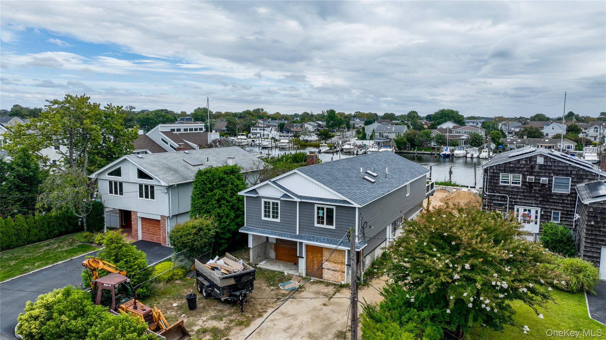 OPPORTUNITY TO CREATE YOUR DREAM WATERFRONT HOME IN THE VILLAGE OF LINDENHURST. THIS FEMA-COMPLIANT, RAISED INLINE RANCH IS MID-CONSTRUCTION WITH THE FRAME ALREADY IN PLACE AND PLANS FULLY APPROVED. THE PROPOSED LAYOUT OFFERS 3 BEDROOMS, INCLUDING A PRIMARY SUITE WITH AN ENSUITE BATH AND WALK-IN CLOSET, 2 FULL BATHROOMS, AND A SPACIOUS OPEN-CONCEPT MAIN LEVEL WITH VAULTED CEILINGS, DESIGNED FOR A GRAND KITCHEN, DINING AREA, AND LIVING ROOM. ENTER THROUGH THE FRONT DOOR INTO AN ENTRY FOYER THAT ACCESSES AN OPEN LOWER LEVEL OFFERING ADDITIONAL POTENTIAL, COMPLETE WITH TWO SLIDING DOORS THAT LEAD TO THE BACKYARD - PERFECT FOR SUMMER HOSTING AND PROVIDING SMOOTH INDOOR-OUTDOOR FLOW. ADDITIONAL FEATURES INCLUDE LAUNDRY ON THE TOP FLOOR, A GARAGE, AND A LARGE DECK OVERLOOKING AN EXPANSIVE BACKYARD AND 50 FEET OF FUTURE BULKHEAD—IDEAL FOR MULTIPLE LARGE BOATS. RETAINING WALLS ARE CURRENTLY BEING INSTALLED ON BOTH SIDES OF THE PROPERTY. NO FLOOD INSURANCE REQUIRED. SELLER IS SEEKING A BUYER TO PURCHASE THE PROPERTY IN ITS CURRENT STATE AND COMPLETE THE BUILD. SELLER IS CONTINUING THE PROJECT UNTIL A BUYER IS FOUND—PLEASE CHECK IN FOR CURRENT STATUS. SELLER FINANCING AVAILABLE.