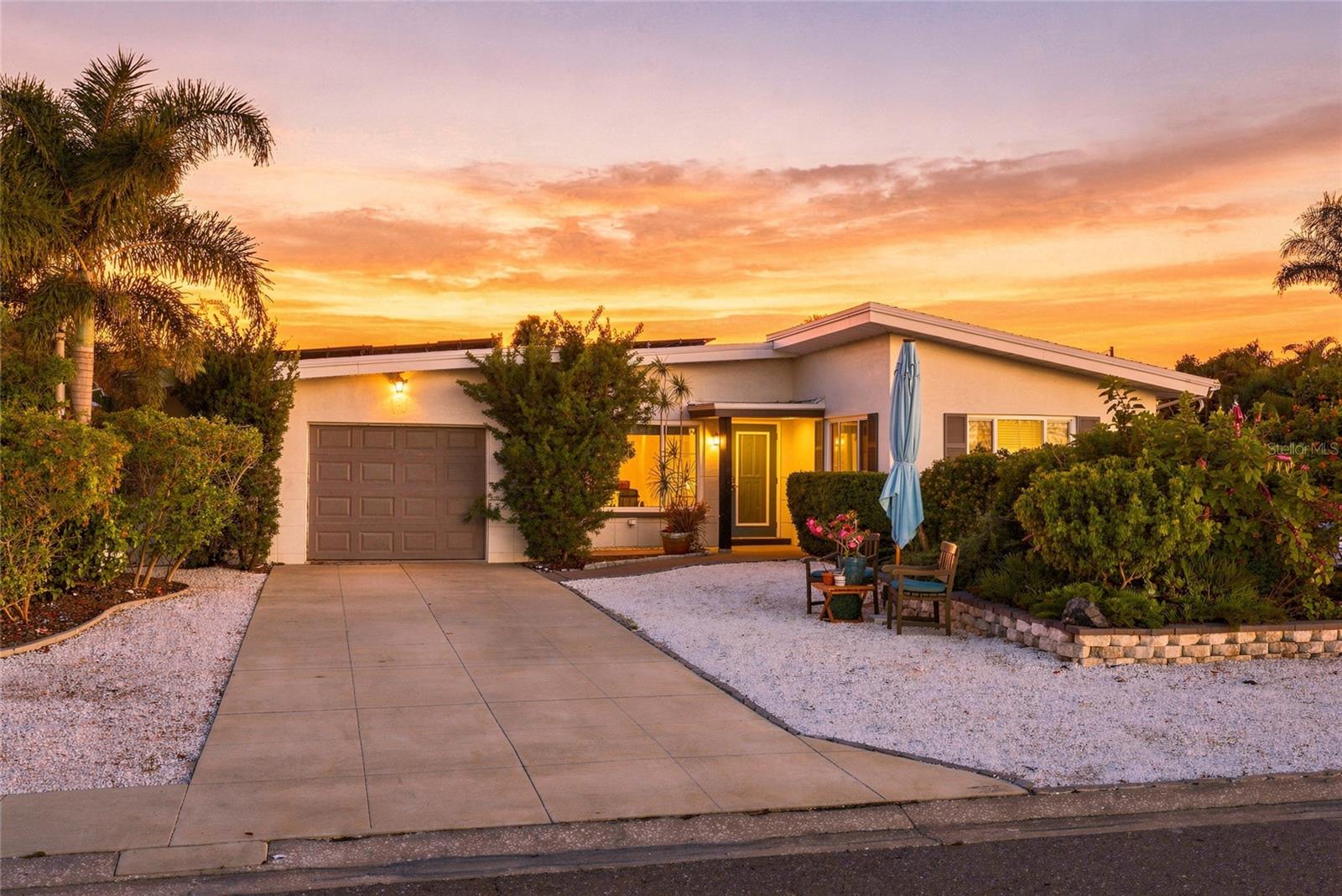 Virtually Staged. MID-CENTURY charm, angled roof line with high ceilings and lush FLORIDA NATIVE landscaping, just minutes from Indian Rocks Beach. No history of flooding. This two-bedroom, one-bath main home with a bonus enclosed Florida room blends preserved vintage details with a new kitchen and thoughtful modern upgrades. An ADDITIONAL STUDIO with a private entrance, full bathroom, hot tub and private yard is currently rented through Airbnb, offering flexibility for visiting family, guests or continued SHORT-TERM RENTAL use. A modern DeGeorge concrete driveway and low-maintenance native landscaping welcome you to this spacious corner lot, with generous courtyards and distinct outdoor spaces for entertaining and relaxing. Approximately 1,350 square feet of gardens feature 80% native plantings, including beautyberry, firebush, coontie and muhly grass, plus fruit-producing plants and trees such as red mulberry, elderberry, passionvine and seagrape. The garden is a Certified Wildlife Habitat through the National Wildlife Federation and a registered Monarch Waystation through Monarch Watch. There is also room to explore adding a pool or parking a boat or RV. Modern upgrades include PGT impact windows and doors, an impact-rated garage door, a Velux impact-rated skylight, plumbing and electrical improvements, electric tankless water heater in 2018 and shingle roof in 2021. Custom roller shades and solar panels enhance energy efficiency, with summer electric bills averaging just $52 per month. Professionally restored terrazzo floors, original bathroom tile in excellent condition, interior wood doors and custom woodworking preserve the home’s character. The new kitchen features custom wood cabinetry, quartz countertops, a granite sink with a chrome faucet and a Big Chill refrigerator that complements the home’s mid-century style. A cypress tongue-and-groove ceiling and skylight add warmth and natural light. The spacious, remodeled Florida room has its own mini-split system, and storage is plentiful throughout. Walk to coffee shops, restaurants, grocery stores and local shops, or bike to the beach. Belleair Causeway’s boat ramp, dog beach and kayak launch are less than a mile away, offering access to nearby barrier islands. Indian Rocks Beach is under four miles. Just 1.4 miles away, the Pinellas Trail offers a paved recreation corridor for walking, jogging and cycling through communities across the county. Tampa International Airport is also within reach for travel and visiting guests. A full list of documented upgrades and all native plants is available upon request. Reach out to schedule a showing.