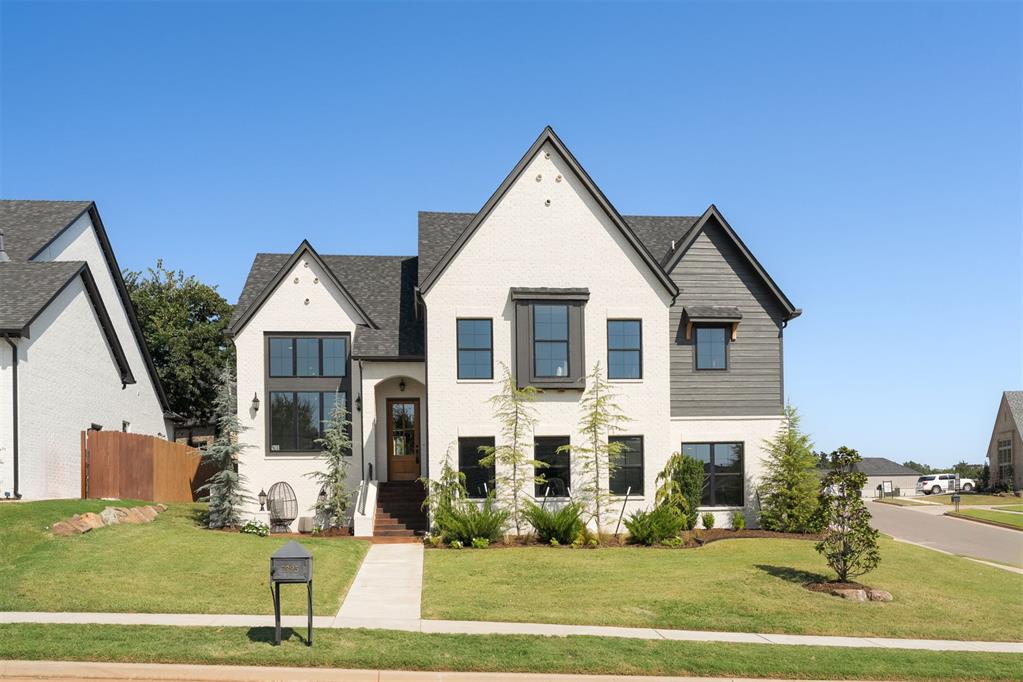 This contemporary English inspired split-level custom home blends timeless design with modern functionality. An office with dramatic windows and tall ceilings greets you when you walk in the timeless, wood front door. The spacious great room features a soaring cathedral ceiling with a stained oak beam and a floor-to-ceiling brick fireplace at its center. The open layout flows seamlessly into the kitchen and dining area—ideal for entertaining. The kitchen is a true showpiece with soapstone countertops, a large island, spice and utensil pull-outs, and a custom stained white oak vent hood that frames the unique backsplash tile. Just off the kitchen, the walk-in pantry offers butcher block counters, cabinetry, and a microwave. The primary suite is just up a half flight of stairs and a retreat with its vaulted ceiling, wall of windows, and spa-like bath featuring dual vanities, soaking tub, glass shower, and a spacious walk-in closet with built-in storage. Down a short half flight of stairs are two secondary bedrooms, a jack-and-jill bathroom and a functional laundry room with lockers complete the thoughtful layout. Outdoor living is equally impressive with an expanded stained concrete patio that provides ample space for gatherings. The striking curb appeal and front porch are welcoming and perfect for front yard handouts. The unique design elements, and color pallet of this home make you feel warm, and welcome. Located on a corner lot in the scenic community of Cottage Grove, residents enjoy tree-lined hills, walking trails, a community park, and a fishing pond—all minutes from I-35, top schools, local grocery stores, local restaurants, medical centers, shopping, and entertainment.
