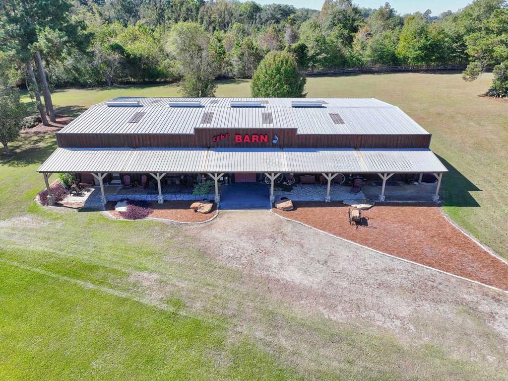 Discover a one-of-a-kind income-producing property that's been a cornerstone of South Georgia entertainment for years! Located just off Highway 19 in Mitchell County—right outside Thomas County—this two-property package spans 5.21 acres and offers incredible versatility for both business and lifestyle.  At its heart is The Barn, a 5,000-square-foot, western-themed event venue honored by the Georgia Country Music Hall of Fame for its lasting contributions to country music. Over the years, this beloved Meigs landmark has hosted countless concerts, weddings, reunions, and community celebrations, filling the air with laughter, dancing, and live performances from popular country bands. With a spacious dance floor, stage, fully equipped DJ booth, bar, and generous reception area, The Barn is completely turnkey—ready for the next owner to start hosting events immediately.  Also included is a 2,120-square-foot, three-bedroom, two-bath home overlooking a peaceful pond, offering the perfect combination of comfort and convenience. You can live onsite while running your event business, or transform the residence into a short-term rental, bridal suite, or housing for entertainers and guests.  Lovingly cared for by its current owner, this property has been a joyful gathering place for many years. Now, it's ready for its next chapter—an opportunity to own a piece of Georgia's musical history while enjoying a profitable, ready-to-go venue that blends Southern charm, community spirit, and endless potential.