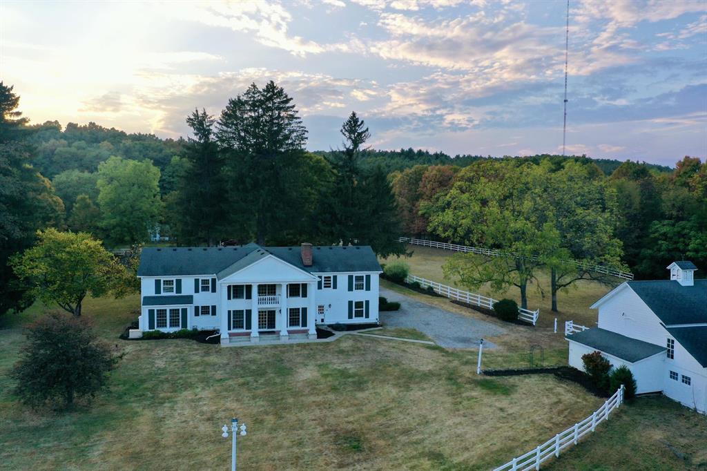 Introducing 8044 Dexter Pinckney Road, a once-in-a-lifetime riverfront estate where timeless character meets endless possibility. On the market for the first time in 57 years, this extraordinary property spans nearly 8 acres with almost 900 feet of private Huron River frontage, framed by Metropark land for unmatched privacy.A sweeping curved staircase welcomes you inside, where crown moldings, formal dining and living spaces, and a first-floor office set the tone. The family room, anchored by a fieldstone fireplace and exposed beams, opens to a sunlit breakfast nook and chef's kitchen with granite countertops and custom cabinetry.Upstairs, all bedrooms are thoughtfully placed, including a primary suite with a Romeo and Juliet balcony overlooking the manicured grounds and river. A private one-bedroom apartment offers flexibility for a caretaker or multigenerational living.The grounds include fenced pastures, multipleoutbuildings, and a 6,000 sq. ft. indoor riding arenaperfect for equestrian pursuits, a wedding venue, or a car collection. Mature trees and curated landscaping complete this rare offering, a true piece of Dexter history ready for its next chapter in luxury living.