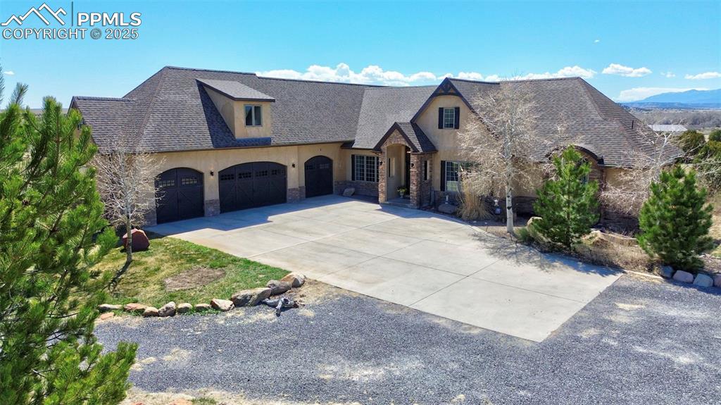 This sprawling home is conveniently located minutes from the interstate, yet feels like a private oasis. As you approach from the private paved drive, a four-car attached garage provides plenty of parking and an electric charger, with a detached RV garage/shop just north of the main house. The elegant entrance opens to a foyer with soaring ceilings and a hint of the natural light that bathes the main floor, coming from the wall of windows in the main-level living room. This room is the heart of the home, with a cozy but elegant wood-burning fireplace and two-story-high ceilings. French doors separate the foyer from an office area that would be convenient for meeting with clients or just working from home with privacy. Formal dining is to the left of the foyer, on the way to the enormous kitchen with eat-in area, oversized refrigerator, huge granite island, Wolf cooktop, custom cabinetry, two dishwashers, copper sinks and a custom vent hood. It is truly an elevated experience to cook and enjoy a meal in this kitchen! Walk out to a large composite deck appropriate for sunning, enjoying summer sunsets or grilling, or add a hot tub to soak under the stars. The generous main-level master suite takes up most of the south side of the main level, with two walk-in closets and an attached bath with a large tiled shower with multiple shower heads and a soaking tub. A huge laundry space and a half-bath for daytime guests round out the main floor. Upstairs is a cheerful loft area, a second family room and/or playroom, a junior suite with attached bath, two more bedrooms and another secondary bathroom. The walk-out basement was finished in 2023 with two more bedrooms, two more baths, an enormous entertaining area, theater room, second laundry area, wine cellar and more! Walk out to a covered, stamped-concrete patio with built-in fireplace. Sitting on a 5-acre lot adjoining 1,400 acres of open space, no expense was spared when this home was custom-built in 2006. New roof in 2024!