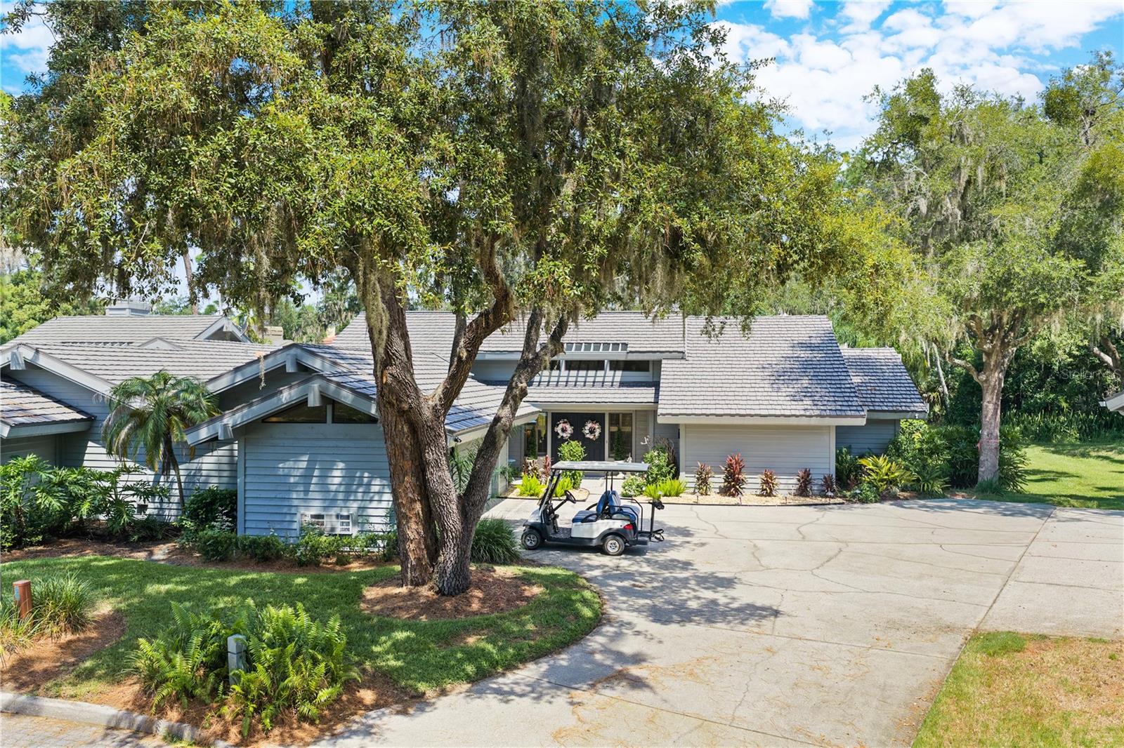 Saddlebrook — a 480-acre nature retreat and the heartbeat of Wesley Chapel — is home to this one-level, 3-bedroom, 2.5-bath cluster home, tucked quietly at the end of a cul-de-sac.A paved driveway leads to a two-car garage and a separate golf cart garage, complete with an included golf cart and new lithium battery and ready for the course. Double doors open into a living room with soaring vaulted ceilings and a wood-burning fireplace, the kind of room that invites you to slow down, with sliding glass doors that open straight out to the lanai and beyond, the mature landscaping, trees and flowers.Just off the living room, a dining room is finished with wainscoting — decorative wood paneling. The kitchen with granite countertops, stainless steel appliances, and its own sliding glass doors opening to a front courtyard, and the sounds of nature.The primary suite is a retreat of its own: vaulted ceilings, a spacious walk-in closet, double vanities, a garden tub, and sliding glass doors to the screened lanai and exterior, private seating area.The HOA takes care of the rest — roof, exterior paint, landscaping, termite control, and trash pickup — backed by 24/7 gated security. Public water and sewer and a Zone X flood designation mean fewer surprises at closing.Right in the community, Saddlebrook Resort offers optional membership to 27 holes of championship golf, tennis, pickleball, and resort dining, with shopping, dining, and hospitals just minutes away. Make an appointment to see this home and visit the community.