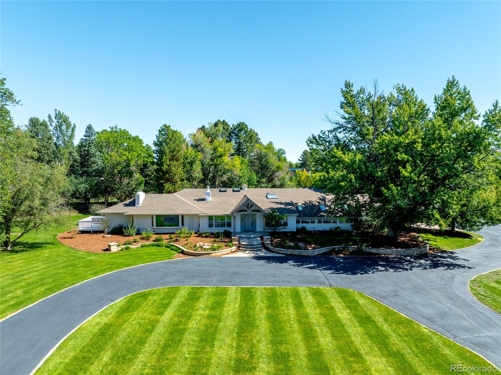 Set on one of the most coveted sites in Cherry Hills, 6 Village offers an excellent opportunity for move-in-ready main-floor living on a large, tree-lined lot, with the flexibility to make it truly your own.The main house has three beds, four baths, with an oversized primary bedroom framed by a large window, a spa-inspired bath complete with steam shower, soaking tub, two walk-in closets, and a private sun deck for early morning coffees. There are two distinct living areas: a sun-filled great room with vaulted, skylit ceilings and a sculptural fireplace, and a den warmed by a stone fireplace beneath handsome post-and-beam ceilings, with a French door framed by sidelight windows opening to the pool. A fully renovated kitchen with a waterfall island and herringbone marble backsplash anchors the home.The guest house adds two bedrooms, two baths, and an office or flex space, with a full kitchen, laundry hookups, and a casual dining nook, ideal for extended family, live-in help, or overnight guests.A separate pool house offers a light-filled lounge with a half bath and floor-to-ceiling glass doors that open onto the lawn, just steps from the classic kidney-shaped pool and its pergola-covered dining terrace, perfect for entertaining under mature shade trees.2.27 acres of mature trees and lush sod, with easy access to the bridle paths,Cherry Hills Village Elementary, Kent Denver, St. Mary's Academy, and University Blvd.