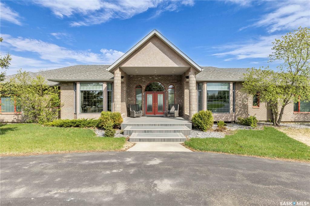 This 3640 sq ft Walkout Bungalow is situated on a 8.8 acre parcel with views of the South Saskatchewan River. With a wonderful location in an active community with rink & play center. Walking into this home, you are welcomed with double-door entry with phantom screens and a spacious foyer leading to an open floor plan with 10 ft ceilings. Great Room features a gas fireplace and custom Redl built-ins, large windows with scenic views. Custom Redl Kitchen is a perfect space with an abundance of cabinets, oversized island with seating, storage, gas cooktop, sink with garburator, granite countertops, baking counter with appliance storage, wall pantry with roll outs, Sub Zero Fridge, built in dishwasher, brand new trash compactor, built-in oven & microwave, coffee bar, dining nook with garden door to composite deck. Formal dining room with a buffet niche. Primary Bedroom is a full retreat with views of the river and access to the deck, gas fireplace with built-ins, dual walk-in closets(1 with stackable washer & dryer), a 4 piece en-suite with in-floor heat, air jet soaker tub, separate shower, dual vanity with granite top & linen closet, sitting area with direct access to basement gym and 3 piece bathroom. Den with a tray ceiling and bayed window.2-piece bathroom with custom stone countertop, laundry room with cabinets, sink, & craft/sewing desk complete the main. Walkout basement features in-floor heat, large family room with 3-way gas fireplace, garden door to covered, partially enclosed patio,games area with wet bar feature seating, fridge,dishwasher & sink. 2 large bedrooms with jack&jill 4- piece bathroom, den/craft room with closet, large mechanical/storage room with wine room. Home is wired for sound system,LED lighting up the driveway, new carpet(2023), new boiler(2023), central vac,4 furnaces & central air, window treatments, & generator for backup power. Attached 8-car heated garage, detached 12-car heated garage/workshop with hoist &cabinets &2-piece bathroom.