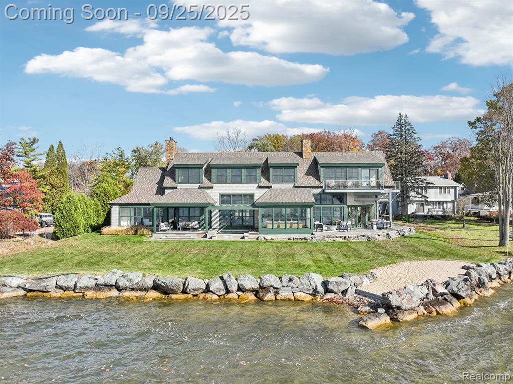 Nestled on all-sports Lake Fenton, this extraordinary lakefront home offers 144 feet of coveted frontage on nearly half an acre of private, waterfront paradise. Thoughtfully reimagined with meticulous craftsmanship, this home combines a warm, modern aesthetic with high-quality materials for premium lake living. The living room centers around a custom stone fireplace, complemented by a family room and sunroom that invite an abundance of natural light and showcase sweeping lake views. The gourmet kitchen, with custom cabinetry and high-end finishes, opens directly to the outdoor space, where a hard-packed sandy beach awaits just steps away for direct water access. On the main floor, a thoughtfully designed guest suite offers privacy with a full bath, ideal for family or friends. Upstairs, the primary suite is a true sanctuary, boasting panoramic lake views, a custom-designed closet, and a spa-like ensuite bath with luxurious finishes. Two additional bedrooms, a full bath, and a cozy sitting area add comfort and functionality, while an optional 5th bedroom or guest suite above the garage includes a private bath, providing versatile living arrangements. The outdoor space is a retreat in itself, with western and southern exposures that frame unforgettable sunsets. An oversized, saltwater hot tub invites relaxation, while the expansive yard offers both privacy and endless views. With heated tile floors on the main level, all-foam insulation throughout, and conveniently located laundry rooms on both floors, this home ensures year-round comfort. Blending elegance, quality craftsmanship, and a one-of-a-kind setting, this property is the ultimate Lake Fenton retreat.