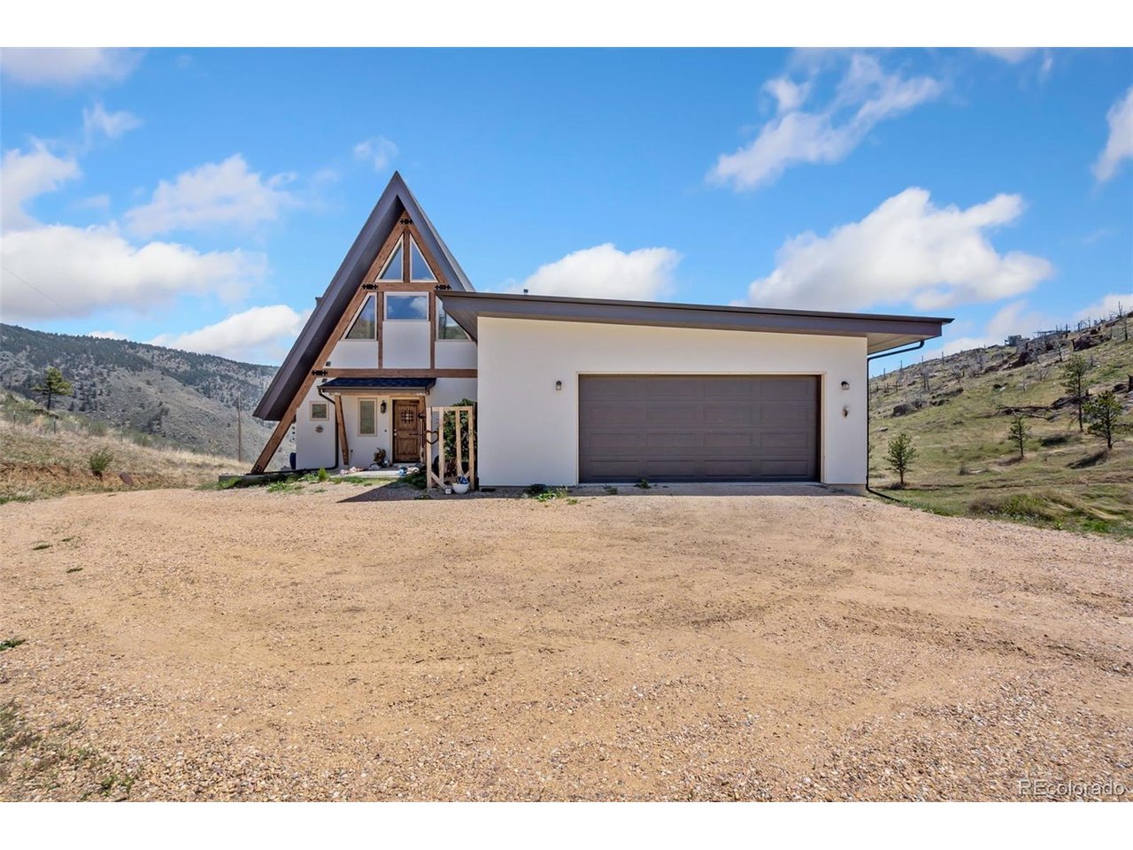 Move to the mountains without giving up the convenience of Fort Collins and Loveland. Located at 405 Moondance Way in Bellvue, this exceptional 2022 custom A-Frame offers the rare opportunity to enjoy 35 private acres in the highly desirable Buckhorn Canyon area while remaining just 20-30 minutes from Loveland and Fort Collins. Tucked inside a private gated community with maintained year-round access, this mountain retreat combines breathtaking scenery, privacy, wildlife, and usable acreage with easy access to the amenities, dining, shopping, and employment centers of Northern Colorado.Offered for the first time, the custom-built home features more than 2,800 square feet of thoughtfully designed living space. Dramatic floor-to-ceiling windows bring the outdoors in and showcase panoramic mountain and valley views from nearly every room. Concrete, steel, and timber accents provide durability and character, while stained concrete floors throughout offer a clean, low-maintenance finish.The chef's kitchen is designed for both everyday living and entertaining, featuring a large island, custom cabinetry, pantry, and stainless steel appliances. Multiple living areas provide plenty of flexibility, including a spacious lower-level family room with convenient outdoor access. The entire upper level is dedicated to the private primary suite, complete with a five-piece bath, walk-in closet, and private deck overlooking the surrounding mountains. Outdoor living is just as impressive, with a wraparound Trex deck offering the perfect setting for morning coffee, entertaining, or taking in Colorado sunsets and abundant wildlife year-round.