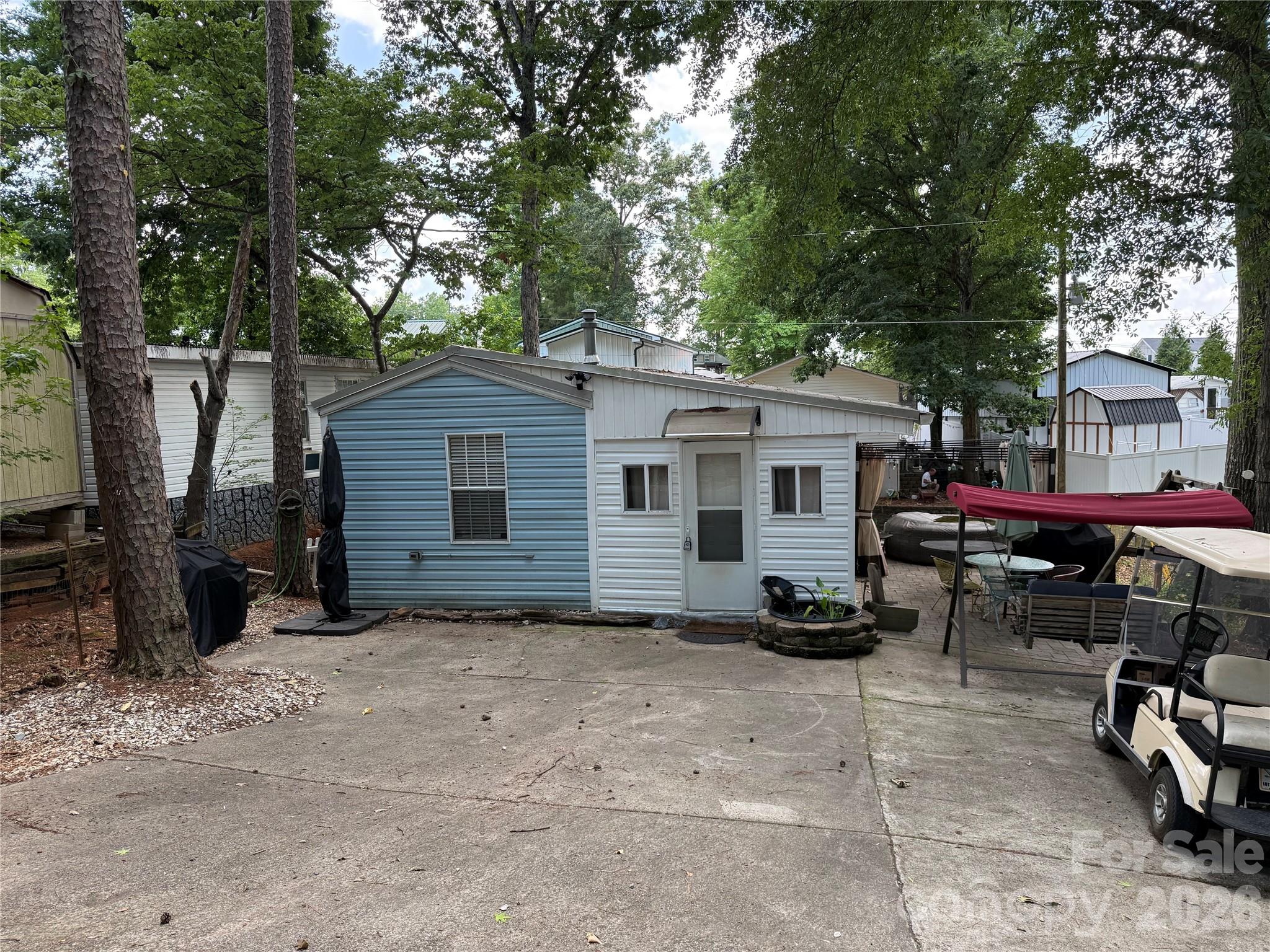 Welcome to 105/107 River Ridge Tr. This double lot property features a 1995 park model with an addition, plus a second unit that is a 30' 2016 Keystone Coleman with 2 slides.  Parking is abundant with space both at the top and bottom of the concrete driveway. Enjoy the extensive outdoor space, highlighted by a cozy fire pit area with peeks of the water in the summer and lovely views in the winter. The exterior is setup perfect for entertaining, featuring a picnic table, a swing, an additional swing frame and a dining area set with four chairs a table and umbrella. The blue building will remain. Park model has 748 square feet.Inside the park model you are greeted by a well-sized living room with a fabulous propane stove and freshly painted cabinets. This home features a dining area with a large window and an awesome pantry with great shelving and a beverage refrigerator. The oversized bathroom offers ample storage and the spacious bedroom includes a nice closet and two queen beds that will remainRecent update include a 3 year old metal roof, new washer and dryer, added gutters and recently serviced the HVAC system. This home also features an on demand propane hot water , a gas line to the patio and a gas line to the dryer (not in use). The sale includes a recently serviced 1992 club car golf card. A must see property for those seeking comfort and convenience.Excluded from the sale are the couch, dining room table, grills, hot tub, white building and large umbrella.  We are leaving the water feature. The sound is soothing. This unit is attached to real estate!!Second unit features a 2016 Keystone Coleman (30') with two slides. This unit includes a primary bedroom with a queen bed and a bunk room with three bunks and an additional twin bed. This unit features a full bathroom with a standard toilet and has been hard plumed to replace the original black tank system. The camper has 299 square feet. Cosmetic updates have been started, including a initial coat of paint; the unit is ready for your finishing touches. Please note: the 2016 Keystone camper has cosmetic wall damage in the main bedroom, resulting from a previous , fully repaired roof leak.Utilities Disclosure, both units are currently operated on a group septic system. The property is in the process of transitioning to an individual system connected to the county sewer line.All buyers have to be a realtor to gain entry to the community.