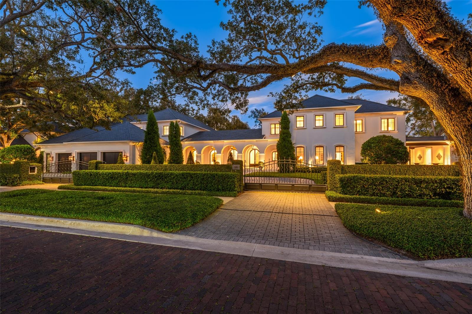 Positioned along 400 feet of beautiful scenic frontage at the Palma Ceia Golf Course, this exceptional South Tampa masterpiece offers impeccably designed living space while outside a flood zone. The gated, treelined estate showcases timeless craftsmanship with a total of nine bedrooms, ten full baths, four half-baths, a detached guest residence, as well as an additional vacant lot all packaged into one offering. The great room is tremendously welcoming as natural light pours through the arched glass doors lining the room, complemented by 15-foot ceilings and the winding grand staircase. Resting in its own private wing of the residence, the primary bedroom is a suite with a substantial dream closet, a separate sitting room and a large balcony overlooking the picturesque backyard green space and golf course. The main kitchen highlights a significant marble island opening to the casual family room, accompanied by a full prep kitchen, stunning butler’s pantry and outdoor kitchen with a brick pizza oven. Additional rooms include three impressive executive offices, a theater room with stadium seating, a fitness center, a 600-plus bottle wine cellar, and an outstanding entertaining parlor enriched by Jack Mayweather handcrafted millwork and coffered ceilings. Key aspects include a timeless slate roof, fully fenced grounds, a three-car garage with two gated circular driveways, a full home generator, two elevators, and a state-of-the-art audio, video and security system that provides modern comforts as well as peace of mind. The outdoor living experience is defined by romantic stone archways, manicured gardens, gas lanterns, Pecky Cypress ceilings, multiple covered balconies, lanai spaces and artistic fountains placed around the grounds. The 48-foot-long, heated saltwater pool and spa are paired with a covered cabana area and an expansive backyard, all while overlooking dramatic views of the golf course. Conveniently in the heart of South Tampa in a top-rated public school district, this location is central to Hyde Park Village, Bayshore Boulevard, downtown Tampa and Tampa International Airport.