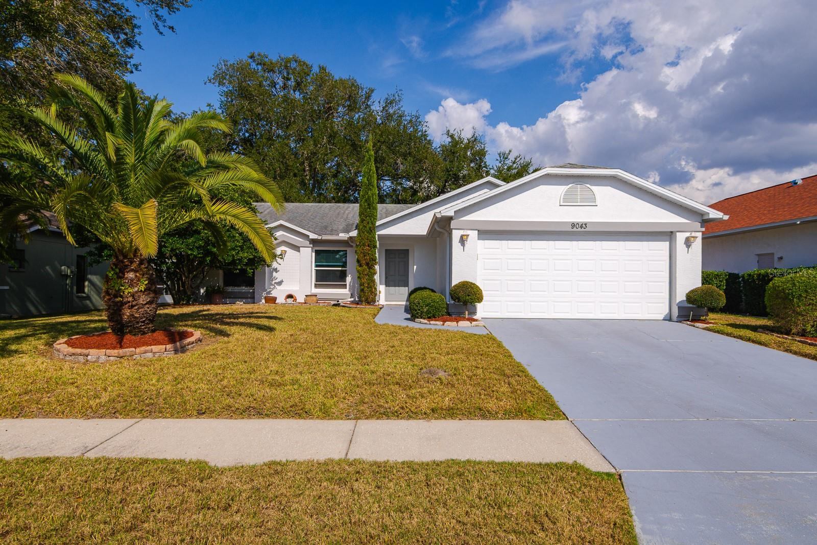 Welcome to this inviting pool home in the sought-after Fairway Oaks community—an ideal opportunity for snowbirds, first-time buyers, or anyone looking to create their perfect Florida retreat. This single-story ranch offers a spacious 3-bedroom, 2-bath split floor plan with a bright great room layout and 1,438 sq. ft. of living space. The open living and dining area flows easily to the screened lanai, where a large in-ground pool and covered patio overlook peaceful green space and a walking path—no rear neighbors, just a quiet and relaxing backdrop. There’s plenty of room for outdoor dining and lounging, making this space a standout feature of the home. Inside, you’ll find tile and laminate flooring throughout, a roomy primary suite with his-and-hers closets, and a private bath with a walk-in shower. While the kitchen and bathrooms are ready for a modern refresh, the home has solid bones, with the roof, windows, HVAC, and water heater all replaced during the 2012 remodel. Fairway Oaks offers low HOA dues, well-kept surroundings, and a convenient Hudson location close to shopping, restaurants, and medical facilities. If you’re looking for a home you can personalize while enjoying a great layout and a beautiful pool setting, this one is not to be missed.