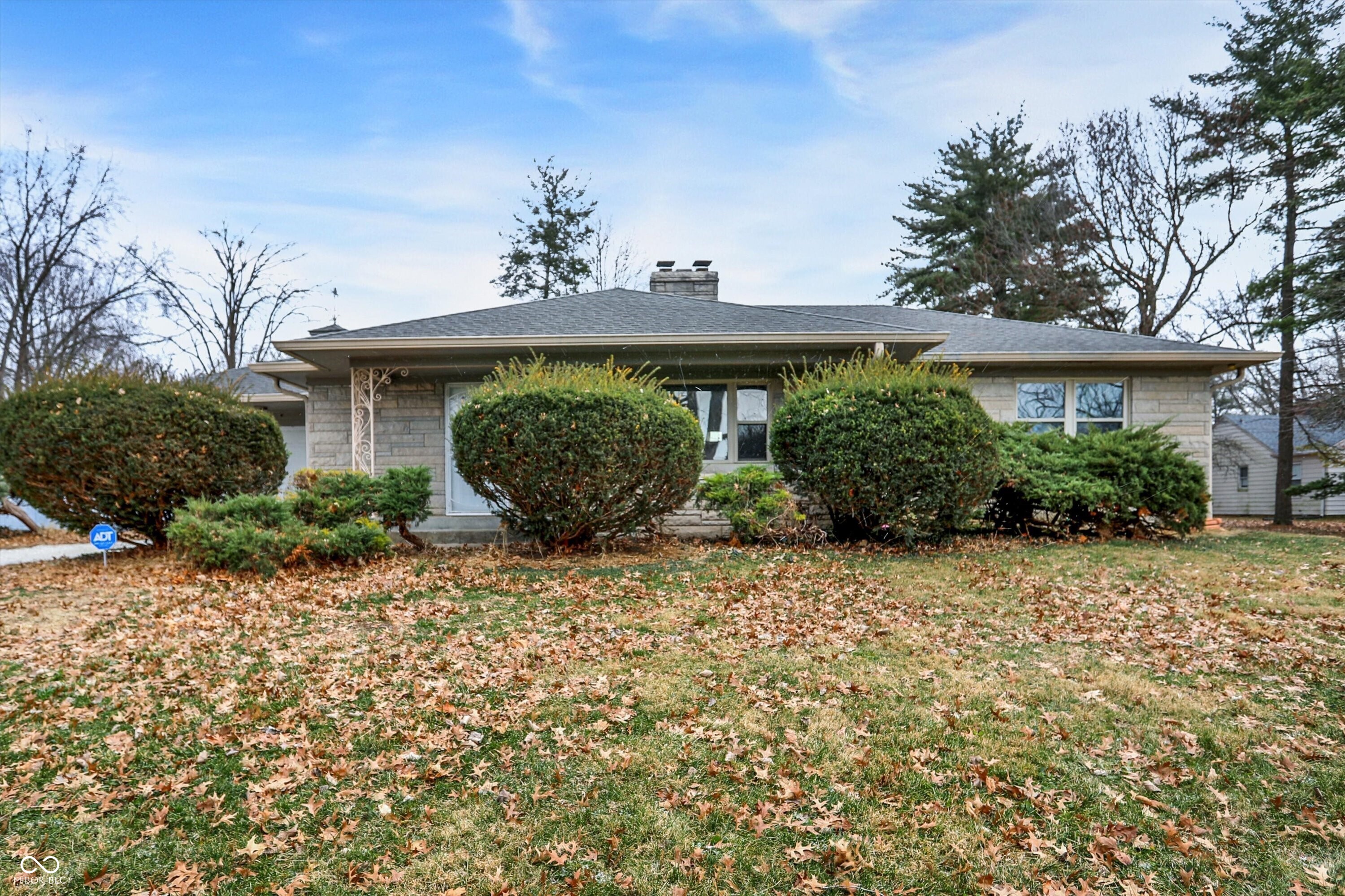 Set on an exceptionally rare 1.5-acre homesite with no HOA, this Bedford stone ranch offers the space, flexibility, and long-term upside buyers are actively searching for while remaining fully livable from day one. The timeless Bedford limestone exterior-an Indiana hallmark-delivers outstanding durability, natural insulation, and low maintenance appeal, while the interior features hardwood floors, a welcoming living room with wood-burning fireplace, and a functional layout that easily supports future modernization. The kitchen and formal dining area provide a solid foundation for cosmetic upgrades over time, allowing buyers to build equity at their own pace rather than taking on immediate projects. Outdoors is where this property truly shines: multiple mini barns and an outbuilding with utilities offer endless possibilities for storage, hobbies, workshop use, or small-scale homesteading, complemented by mature trees, a fire pit area, and expansive open yard rarely found this close to city conveniences. A partial basement provides additional storage and flexibility, and the attached garage adds everyday practicality. Conveniently located in Beech Grove with quick access to downtown Indianapolis, major commuter routes, schools, parks, and everyday amenities, this property presents a compelling opportunity for buyers seeking land, privacy, and future value without sacrificing comfort or location.