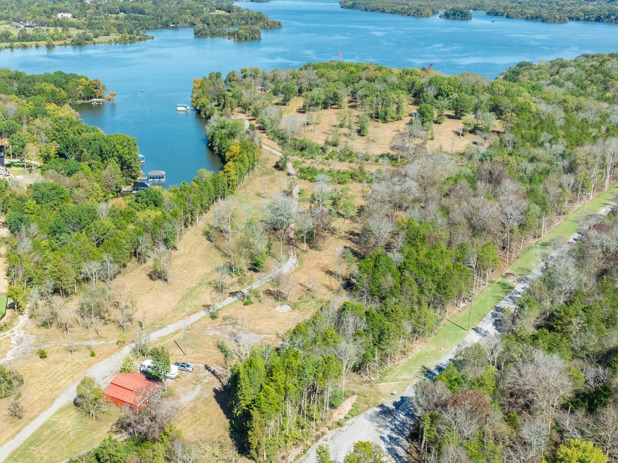 Discover an incredibly rare 21.07-acre private sanctuary tucked away on a deep-water cove of Old Hickory Lake—one of the last remaining undeveloped tracts of its kind. This is not simply land—it’s a once-in-a-generation opportunity to create a legacy property on Old Hickory Lake, where privacy, scale, and waterfront access rarely converge. The 26 acre directly behind the property is a generational estate that will not be developed - offering unrivaled privacy.With rolling hills that cascade toward the shoreline and sweeping views of the lake, this property is the ideal canvas for a world-class private estate or legacy compound. This parcel is already approved with four separate dock permits (one for each 5-acre surveyed tract), providing unmatched flexibility. Each tract enjoys approximately 195 feet of water frontage and a minimum of 15 feet water depth year-round—perfect for large vessels, swimming, and recreation. A private gated road from Nonaville Road runs the full length of the acreage, ensuring exclusivity and privacy. The homesites themselves are invisible from the road, creating a true retreat that feels worlds away—yet is only 25 minutes to Nashville International Airport and the vibrancy of downtown. City sewer is available at the road for convenience and future development. While the land is also listed individually in four individual 5+-acre tracts as well, the true value lies in preserving the full estate—an opportunity to claim one of the most unique and irreplaceable holdings on the lake. Buyer preference will guide the final configuration—whichever option goes under contract first will define the remaining availability. The seller is also a builder and can provide custom home design and construction. Located in coveted Wilson County, known for both its natural beauty and strong growth trajectory, this property offers the rare combination of privacy, prestige, and long-term investment potential. An appointment must be scheduled to view.