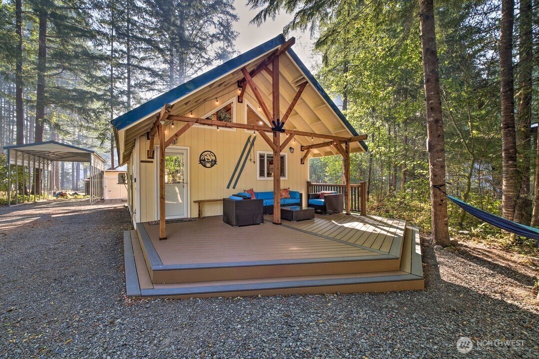 Tucked into a peaceful, forested cul-de-sac, this cozy cabin is the perfect escape—just minutes from Mount Rainier National Park and White Pass Ski Area. Inside, you’ll find warm Randle Woods cabinetry, unique live edge countertops, and an efficient layout that maximizes space and comfort. The main level offers a primary bedroom, full bath, and a flexible office or extra sleeping space. A spiral staircase leads to a spacious loft with two separate sleeping areas. Enjoy both covered and open decks, a fire pit for evening gatherings, and year-round comfort with a ductless heat pump and woodstove. High Valley HOA amenities include pools, a 9-hole golf course, and water service. Cameras are not conveying.