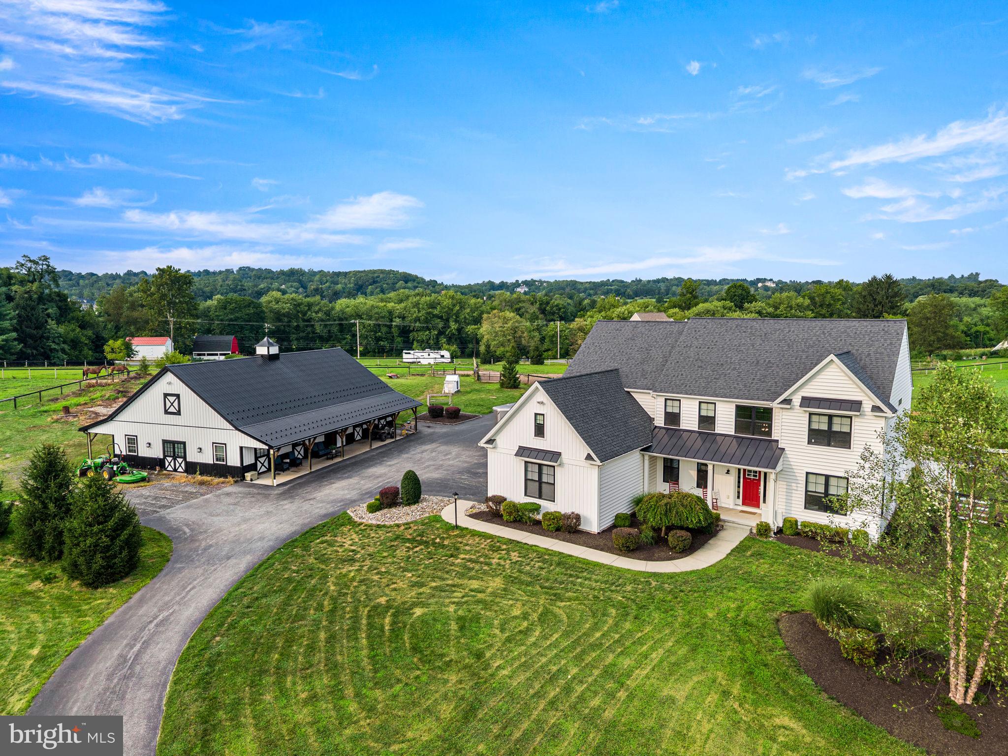 Opportunities like this are hard to find in Chester County—a 10-acre equestrian farmette with a custom home, pool, barn, riding arena and paddocks, all established within the past six years! Welcome to this exceptional property, where a gated entrance opens to approximately 10.1 acres designed for comfortable country living and the equestrian lifestyle.The custom-built Rotelle home offers a thoughtfully designed floor plan filled with quality finishes and special touches. A two-story foyer welcomes you inside, with a formal dining room, private office, powder room and living room featuring a built-in bar area. The heart of the home is the impressive two-story family room with vaulted ceiling, fireplace, shiplap accent wall and reclaimed-style barn beam mantel.The adjoining gourmet kitchen is designed for both everyday living and entertaining, featuring a farmhouse sink, oversized center island, quartz and soapstone countertops, gas cooktop, double wall ovens, built-in drawer microwave and convenient secretary/work area. Barn doors lead to the mudroom, while the breakfast area opens through sliding glass doors to the covered rear patio.Step outside and enjoy your own private retreat. The extensively landscaped backyard surrounds a beautiful in-ground pool with adjoining hot tub, creating the perfect setting for relaxing or entertaining while enjoying the peaceful views of the property. Engineered hardwood flooring flows throughout the main level.A split staircase leads to the second floor, where an open hallway overlooks the family room below. Three generously sized secondary bedrooms share a hall bath with tub/shower. The spacious primary suite features walk-in closets and a private bath with custom cabinetry and a glass-enclosed shower. An additional partially finished room over the garage, accessed from the primary suite, provides flexible space for an office, dressing room, additional closet space or storage.The unfinished lower level offers 9-foot ceilings, plumbing for a future bathroom and walk-up stairs to the rear yard, providing excellent potential for additional finished living space. The electrical system has been upgraded with dual 200-amp service.Equestrians will appreciate that the farm is ready for both horse and rider. The custom-built barn features four 12' x 12' stalls, a wide center aisle, wash stall with hot and cold water, heated tack room and laundry area. A finished multipurpose room with a full bath and kitchenette adds tremendous versatility.Outside, the equestrian amenities continue with a fenced round pen, outdoor riding arena and four fenced paddocks, including two with run-in sheds and automatic waterers.Whether your dream is to keep your horses at home, enjoy the privacy and beauty of 10 acres, entertain poolside, or simply embrace the Chester County country lifestyle, this property brings it all together. A newer custom home, exceptional equestrian amenities, acreage and resort-style outdoor living—all in one remarkable property.