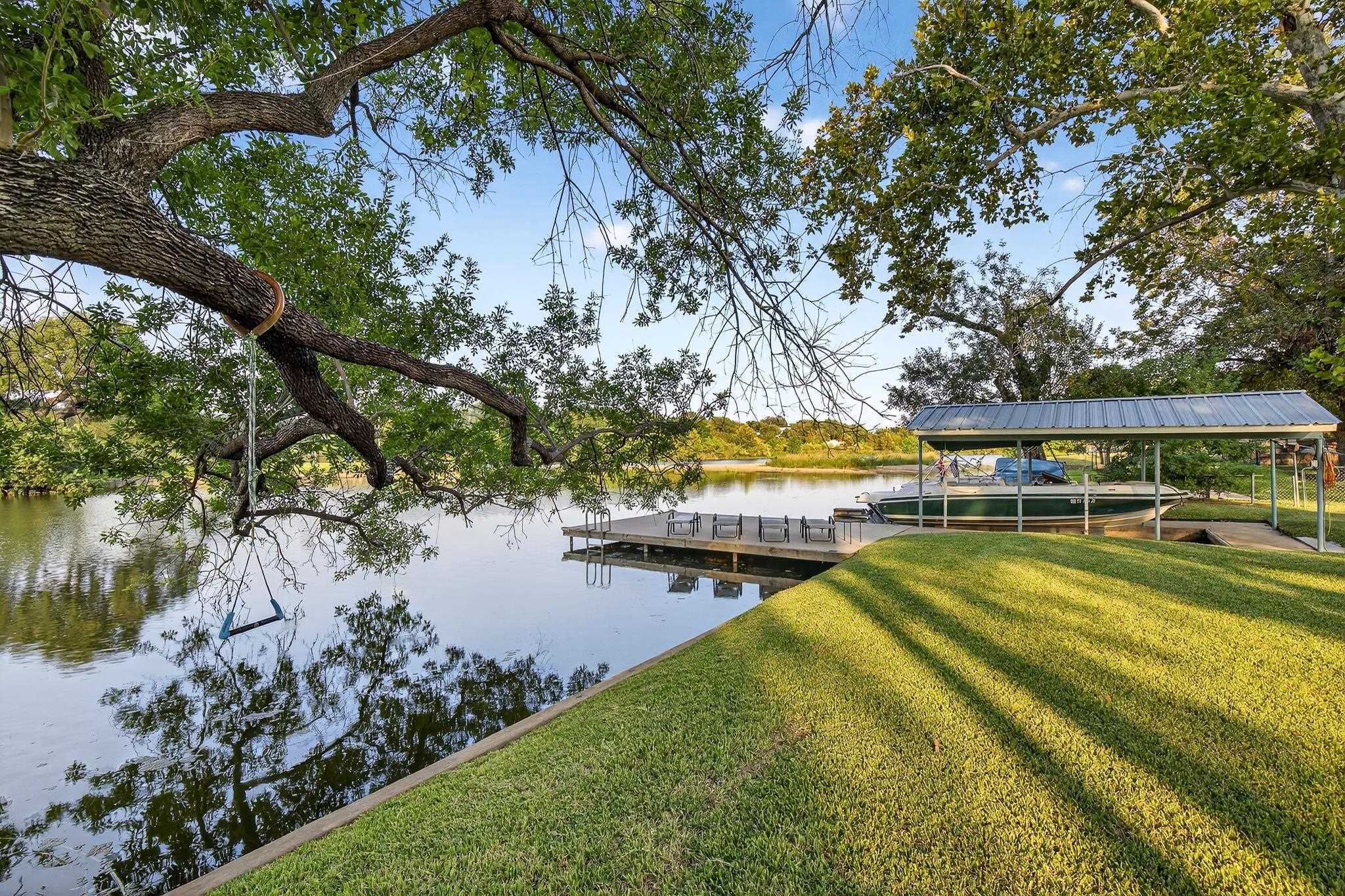 Welcome to 710 Sandy Harbor Drive, a charming retreat tucked away in the tranquil neighborhood of Sandy Harbor on Lake LBJ.  Known for its peaceful setting and easy lake access, this area is perfect for boating, fishing, kayaking, paddleboarding, or simply soaking in the natural beauty.  This adorable home has been thoughtfully updated with fresh interior and exterior paint, all new windows, improvements to the primary bedroom which overlooks the large backyard, a new back patio, and driveway. Outside you'll find a large covered back porch, the new patio, and a sitting area down at the water next to the boat slip and 2 personal watercraft slips.  Located just minutes from both Horseshoe Bay amenities and Kingsland, you'll enjoy the best of lakeside living with nearby convenience. (Membership required to enjoy full Horseshoe Bay Resort amenities. No STR allowed).