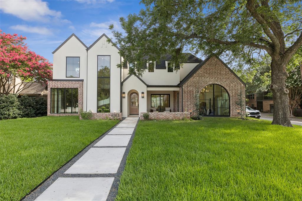 Located on a large corner lot in the heart of Lakewood Heights, this timeless 5 bed, 7 bath new construction by BuildTX Solutions and designed by CH Design Studios leaves no detail overlooked. Bathing in natural light, the herringbone entry makes an incredible first impression. The main living area offers a generous entertaining space, flowing seamlessly into the sophisticated kitchen with top-of-the-line Viking appliances and a prep pantry with a workstation sink conveniently located behind the kitchen and next to the dining room. Adjacent to the kitchen, the breakfast nook showcases exotic natural stone framed by custom cabinetry and a dedicated wine storage area. The large dining room is flooded with natural light with windows on each exterior wall and a 20 ft vaulted ceiling. On each side of the living room, sliding doors lead to a front covered patio with beautiful limestone floors and an expansive covered outdoor living area overlooking the spacious backyard. First-floor primary is a secluded retreat with direct backyard access. The primary bath features natural stone floors, dual white oak vanities, a large soaking tub, and a fully custom closet that connects to the laundry. A convenient side entry for catering and services connects the mudroom and garage to the first-floor guest quarters. The elegant spiral staircase with custom rod iron railing leads to the second floor. Game room, half bath, flex space (gym or 2nd office), and 3 ensuite secondary bedrooms complete the second floor. A short stroll to Lakewood Country Club, Whole Foods, and Lakewood Shopping Center and just 10 minutes to downtown.