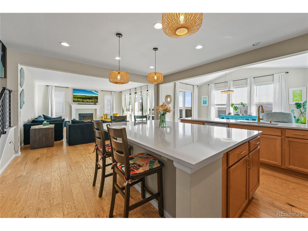 Experience one of Reunion's most upgraded homes, featuring the largest floor plan in the community with premium builder upgrades and thoughtfully selected post-closing improvements. Designed for everyday living and entertaining, this home offers a sunroom addition, a fully finished basement with a recreation room, bedroom, and full bath, plus a private covered patio that extends your living space outdoors.The gourmet kitchen features upgraded painted cabinetry, expansive quartz countertops, a large center island, designer tile backsplash, an exterior-vented hood, and an open layout that flows seamlessly into the great room and sunroom. The spacious primary suite offers coffered ceilings and a spa-inspired bath with an expanded euro glass shower, rain shower head, upgraded tile, quartz countertops, and designer champagne bronze fixtures. The owners replaced the Roman tub during construction to create a larger shower and expanded walk-in closet.Additional upgrades include engineered hardwood floors, custom lighting, designer tile throughout, cable-style stair railings, structured wiring, dual-zone HVAC, gas lines for the range, dryer, and outdoor BBQ, a designer fireplace surround, and an oversized 3-car garage.Post-builder improvements include a whole-house water filtration and conditioning system, fresh-air intake integrated into the HVAC, copper plumbing, radon mitigation, a high-efficiency water heater, a full sprinkler system, and a fully fenced backyard. Outdoor living is enhanced by a putting green currently in progress and an outdoor ceiling fan on the covered patio.Located in the award-winning Reunion community, enjoy miles of trails, parks, pools, a recreation center, Buffalo Run Golf Course, schools, community events, and convenient access to DIA, E-470, shopping, and dining.Comparable model at 18950 E. 96th Place sold for $855,000 in November 2025 with similar premium upgrades.