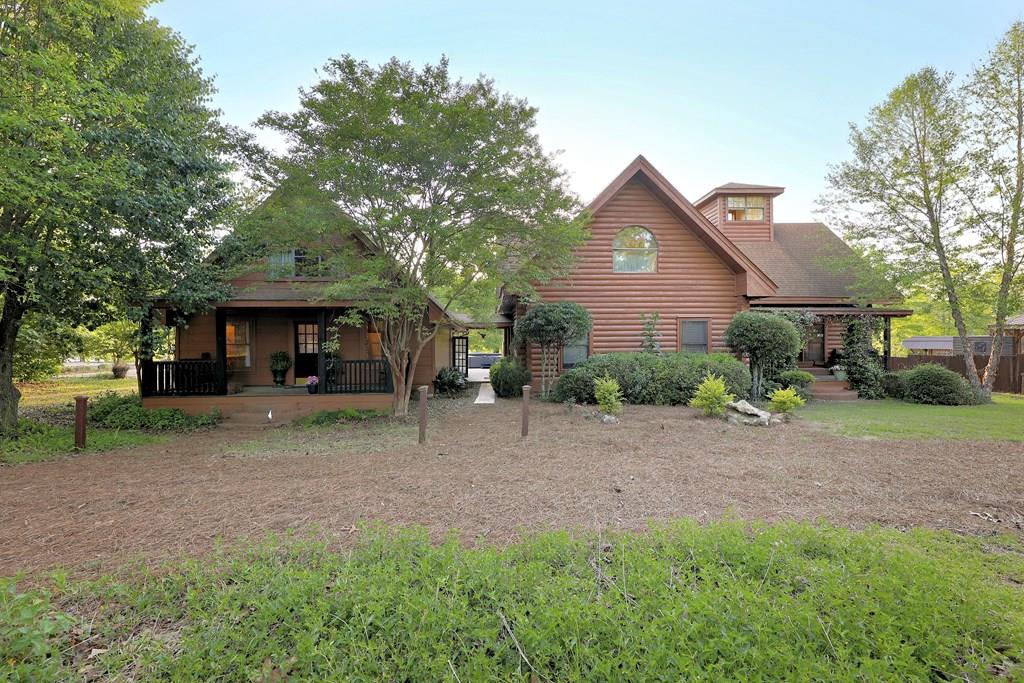Nestled on the serene shores of 37,500-acre Lake Seminole, this magnificent log cabin offers a unique blend of rustic charm and modern comforts. Boasting 20 foot vaulted and beamed ceilings, the spacious living areas provide an airy and inviting atmosphere perfect for both relaxation and entertaining.  With a 15-year history as a successful vacation rental, this unique property can be used as a long-term investment or kept as a special retreat or family and friends.  Tastefully decorated and thoughtfully equipped, the home can be sold with nearly all furnishings and contents.  As you enter the main cabin from the storybook front porch, you will find a handsome and generously proportioned living room, overlooked by a loft that can be used for additional guests, workout equipment, or a quiet place to read.   A gourmet kitchen complete with new granite countertops, two cooktops, double ovens and a breakfast area dining area that overlooks the tranquil waters of the lake. Floor to ceiling windows in the substantial dining room overlook the beautiful grounds.  Numerous, well-placed windows throughout the cabin ensure that you are always connected to the beauty of the outdoors.  The pine floors and timber- trimmed interiors remind you that you are in a special place, far from the worries of city life.    Upstairs, you will find the considerable master bedroom, with a huge in-suite bath, featuring a large whirlpool tub, separate shower, new countertops, and a generous walk-in closet.  Take your breakfast on the covered balcony or nap in privacy after a long day on the water. Adjacent to the main cabin, the self-contained guesthouse offers privacy and convenience for visitors. This charming guesthouse includes a comfortable living space, a well-appointed kitchen, and two ample bedrooms, making it an ideal retreat for guests.  Outdoor living is a highlight of this property, with a screened porch that allows you to enjoy the fresh lake breezes without the nuisance of insects. For the fishing enthusiast, a pier or boathouse may be built on the shoreline.  The adjacent lot, also for sale, features a pier and a boathouse and may be purchased (89K) with the property in a single transaction, ensuring that your aquatic adventures are always at your fingertips. The cupola atop the cabin provides stunning views of the lake, offering a perfect spot to watch the sunset or enjoy a quiet moment of reflection.  There is also a large hot tub for cool evenings. Only a short drive from Thomasville, Bainbridge or Tallahassee, this lakefront log cabin estate is a rare gem, combining timeless beauty with modern amenities. Whether you are looking for a peaceful getaway or a place to host family and friends, this property is sure to exceed your expectations.