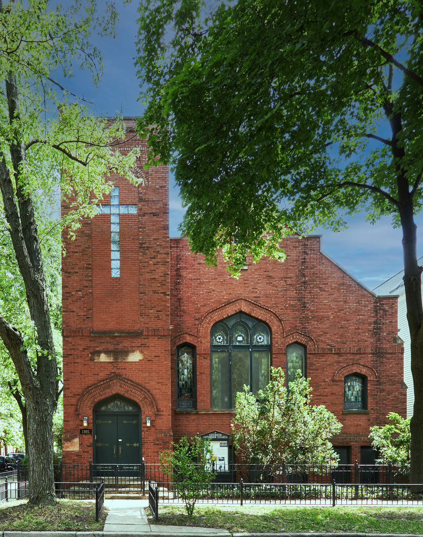 Situated in the absolute heart of Roscoe Village, this distinguished corner church has been spectacularly converted into a sprawling single-family estate. The handsome red-brick building spans over two city lots and offers approximately 10,000 square feet of magnificent living space. Despite its grand scale, the home is designed to feel remarkably private and surprisingly intimate. The property features 5 bedrooms, 4 full baths, 2 half baths, and 2 kitchens. The definitive highlight is the former nave, transformed into one of the most spectacular living rooms in Chicago, complete with 25-foot vaulted ceilings and original beams and woodwork. Natural light fills the room, filtered by the breathtaking restored stained glass windows. New herringbone quarter sawn oak floors are stunning throughout. The striking bell tower is accessible via an interior staircase that provides sweeping neighborhood views. The main level kitchen features a mix of new and retrofitted antique cabinetry, chef's appliances, and abundant storage. The dining room opens to a private rooftop terrace tucked nicely behind the crenellated parapet wall. Three guest bedrooms are located in their own wing; one en-suite and the other two sharing a bathroom. One of the bedrooms, currently configured as an office, features a breathtaking fireplace. Rooms are spacious and private, offering fantastic natural light. The primary suite is sprawling with vaulted ceilings, multiple sitting areas, 2 large walk-in closets, a laundry setup, and a large bathroom with a separate tub and shower. It's truly a home within a home. The lower level offers a massive family room with a wet bar, catering kitchen, and mud room leading to the attached two-car garage. There is also a large gallery leading to the guest suite, which has an en-suite bathroom and separate entrance, making it the perfect private retreat. Several efficient mechanical systems keep the house comfortable year round including sub-slab radiant heat and beautiful historical radiators. The well-planned systems create a living environment that is both comfortable and efficient. The location is perfect, just steps to Roscoe Village dining and shopping along Damen, Lincoln, and Roscoe. Located in the Audubon school district and just steps to the Paulina Brown Line station.