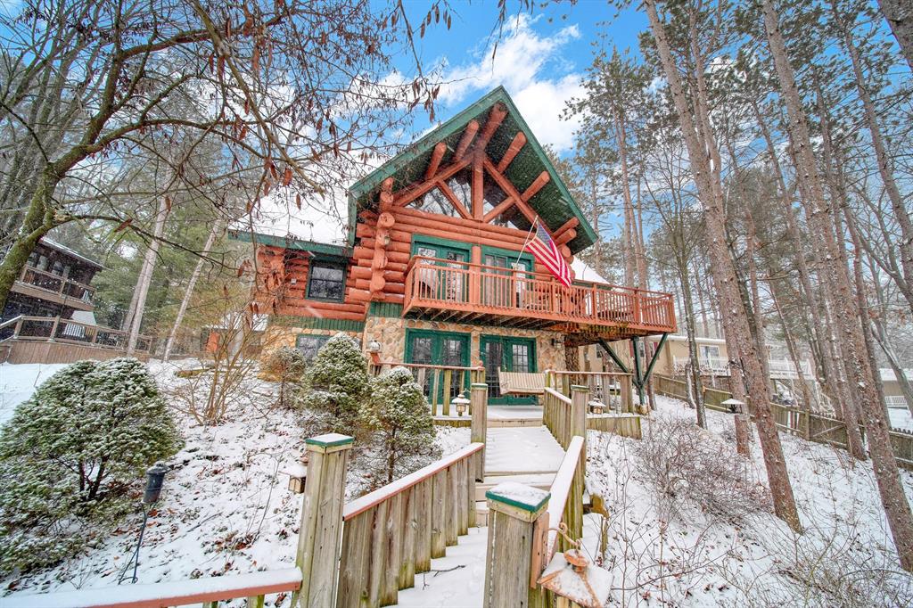 You'll love this stunning custom built log home on a gorgeous chain of lakes with that up-north feel without the long drive! This home features beautiful logs brought in from Drummond Island, an open floor plan, cathedral ceilings and endless character & charm! The walkout lower level is finished, includes kitchenette, spirits room, and plenty of entertaining space. A large detached 2+ car garage has a finished loft (heat and air) and room for plenty of storage. Though your neighborhood feels like a vacation community, your new home is just about 15 minutes from Jackson, Mi. This lovely lakefront home with boasts a custom fire pit and 3 docks giving you everything you need to make lifetime memories.****Please watch Video*** Next to Photos***