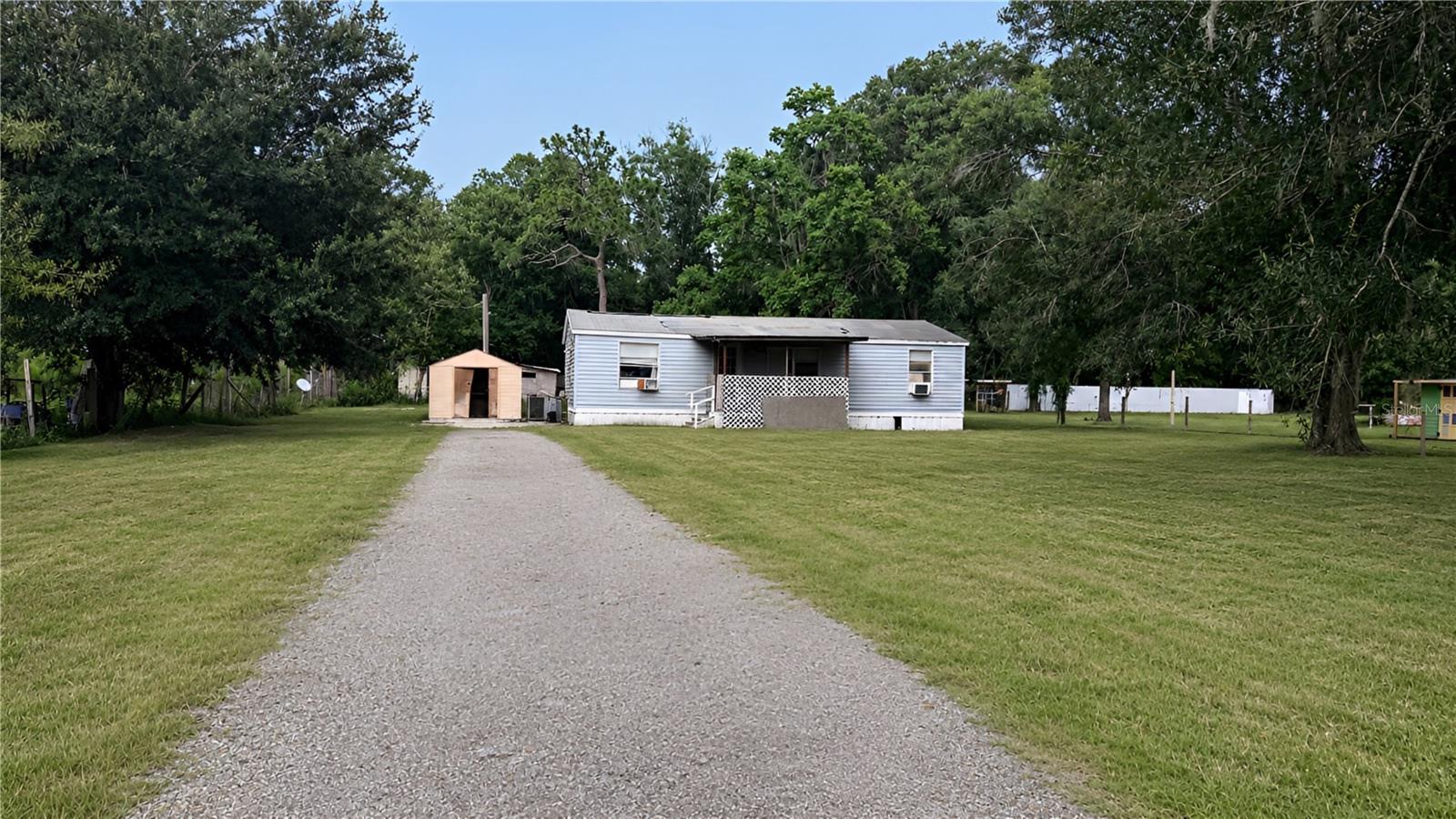 INVESTOR / HANDYMAN SPECIAL • MASSIVE POTENTIAL • INCREDIBLE .63 ACRE LAND OPPORTUNITY!Positioned on a fully fenced and gated 0.63-acre parcel with AR (Agricultural SFR/MH) zoning, this property presents an exceptional opportunity for investors, builders, cash buyers, or anyone looking to create their own private homestead.The existing 3-bedroom, 2-bath manufactured home is approximately 960 square feet, features a split-bedroom floor plan, and includes an attached rear porch. The structure requires substantial rehabilitation or removal, making this the perfect value-add project or future homesite.HIGHLIGHTS:No HOA & No CDD Restrictions: Enjoy the freedom to park RVs, boats, trailers, work vehicles, and recreational equipment without restrictive community regulations.Flexible Zoning: Renovate the existing structure, replace it with a new manufactured home, or build your dream site-built residence (buyer to verify all intended uses).Added Utility: The spacious lot is beautifully shaded by mature trees and includes two storage sheds—perfect for securing tools and equipment while you plan your next project.LOCATION, LOCATION, LOCATION!Tucked away in Angus Valley for ultimate rural privacy, you are just minutes from Old Pasco Road, I-75, schools, hospitals, and all the premier shopping and dining of Wesley Chapel.Whether you're planning your next flip, adding to your rental portfolio, securing a future homesite, or investing in land within one of Pasco County’s fastest-growing corridors, opportunities like this are becoming increasingly rare at this price point. Bring your vision and unlock the endless long-term equity potential of 6408 Woodsman Drive!