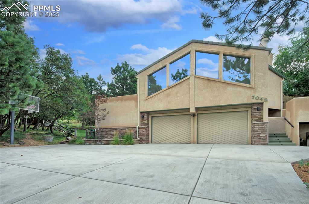 Discover this meticulously maintained home in a serene setting which sits on a 1.3 acre Beautiful private lot with Mountain & City Views from many places inside & out.  This residence boasts tons of timeless Colorado charm. Step inside and be greeted by a light-filled, inviting atmosphere, showcasing thoughtful design and unique floorplan.  When you walk in you are greeted by 22 x 10 sunroom w/ city and mountain views & gas fireplace. The inviting great room with vaulted ceilings & exposed wooden beams are enhanced by large windows with great mountain views along with a stone wood burning fireplace!! The kitchen is unique with a newer stainless refrigerator w butlers pantry and a workspace, ample wood cabinetry & recessed lighting. Great possibilities to open this kitchen to make it a great room concept!
 private primary suite located on the upper level w/ gas log fireplace & private deck with city views to enjoy your coffee. Adjoining primary bathroom has been updated to include- free standing soaking tub, beautiful tile shower, Large Double vanity w granite counter & walk-in closet. One secondary bedroom has a walkin closet and several closets have cedar. The lower level bedroom 4 has a large wall of bookshelves, garden level windows & also could be an office. Wow 3 different decks for entertaining and to enjoy the outdoors in Oak Hills with City or Mountain Views 
The garage is oversized with a storage room and wonderful shelving along with a work bench, the backside of the garage has a nice attached shed and secret wine storage nook. Additional parking next to the garage.
Located minutes to award winning District 20 schools, hiking trails, shopping & dining with easy access to I-25. Surrounded by natural splendors with views, wildlife and privacy, this home reminds you of why you love to live in Colorado.