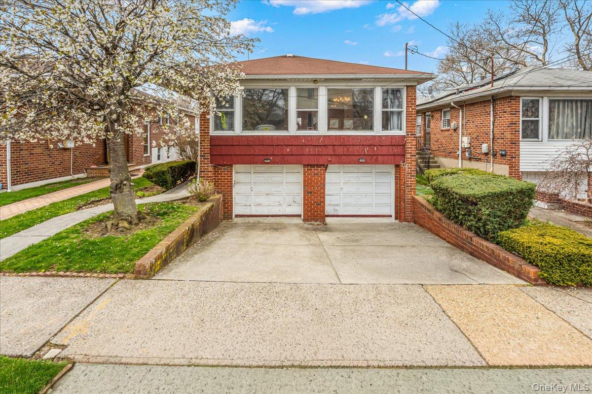 Welcome to this spacious and sun-filled 3-bedroom, 2.5-bathroom Hi-Ranch in the heart of North Flushing. This well-maintained home offers an exceptional layout, starting with a bright, open-concept living and dining area that flows seamlessly into a large eat-in kitchen, ideal for both daily living and hosting. The primary suite serves as a true retreat, complete with its own private full ensuite bathroom. The expansive lower level adds incredible versatility to the home, featuring a generous recreation area, a potential home office, and a separate laundry room. This level also provides direct access to the private backyard and the rare attached two-car garage. A private two-car driveway complements the garage, offering a total of four off-street parking spots! Enjoy the best of residential living with incredible local amenities just moments away. Explore the scenic trails at Bowne Park, the playgrounds at Flushing Fields, or take advantage of the proximity to PS 21 and JHS 185. With local shopping, diverse dining, and easy access to the QM2 Express Bus to Manhattan, local lines, and major highways, this home perfectly balances suburban comfort with city accessibility.