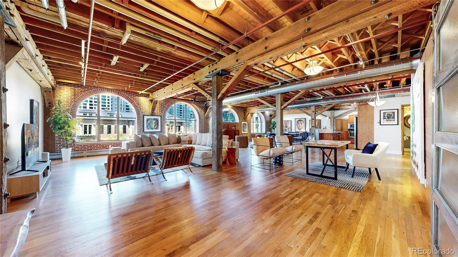A rare offering, two character-rich loft residences thoughtfully combined into one, located within the prestigious Streetcar Stables in the heart of the coveted LoDo district, directly across from Union Station. This fully updated home features 2 beds, 3 baths, 3,000 sq. ft. of living space, and 2 underground parking spaces. The historic residence showcases exposed brick, heavy timber beams, expansive open living areas, and stunning views of Union Station. Rich hardwood floors & dramatic arched windows fill the home with natural light. The open-concept layout is ideal for entertaining & everyday living. Authentic industrial details, steel accents & warm wood tones, add depth and character. The primary suite serves as a private retreat, complete with a spa-inspired bath featuring a sleek double vanity with rich wood cabinetry, an oversized glass-enclosed steam shower, and a freestanding soaking tub that serves as a striking design centerpiece. A versatile 2nd bedroom with an ensuite bath offers flexibility for guests, a home office, or creative use. Ideally located in the heart of the city, you are just moments from Denver's finest dining, coffee, nightlife, & cultural destinations, offering the perfect balance of energy and livability. About Streetcar Stables: The four-story red brick commercial building was constructed as a car barn and horse stable for the Denver City Railway Company. The 1883 building served as the main terminus for Denver’s first public mass transit system until 1892, by which time cable and electric car systems had emerged.  From 1902 to 1972 the building housed the Hendrie and Bolthoff Manufacturing and Supply Company.  It was added to the National Register of Historic Places in 1979. Construction on the 43 loft residences began in late 1993 or early 1994.  The first buyers began moving in early 1996 at sale prices in the low $200’s.  As of early 2026, there are some original owners, whether full or part time, still occupying their homes.