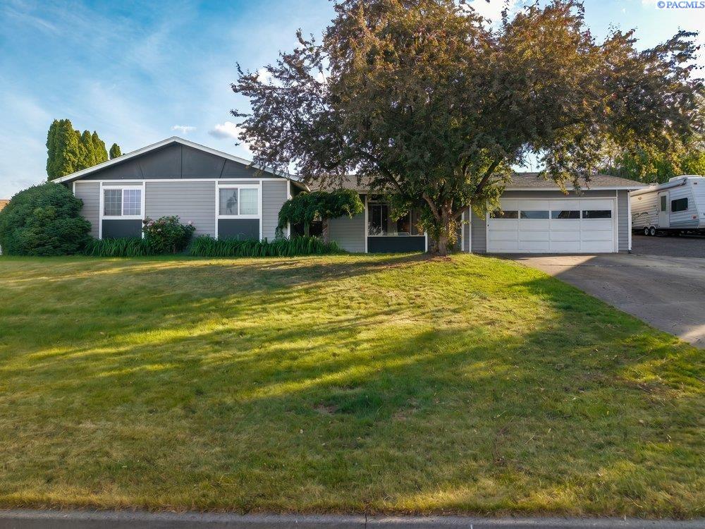 MLS# 293259 Well-maintained 3 bedroom plus flex/office space, 2 bathroom home located in a highly desirable South Kennewick neighborhood. This spacious home features an open-concept layout with a large kitchen island, bar seating, and multiple living and entertaining spaces throughout. The kitchen opens seamlessly to the main living area and covered patio, creating great indoor/outdoor flow.The primary suite includes its own private bath and direct slider access to the covered patio and backyard retreat. A partially enclosed covered patio area offers flexible space for a rec room, workout area, hobby space, or additional storage.Step outside to enjoy the mature landscaping, fully fenced backyard, and exceptional privacy. The backyard features a tranquil pond with water feature, covered gazebo, expansive lawn space, and an above-ground pool with built-in deck, perfect for entertaining and summer enjoyment.Additional highlights include abundant driveway parking, boat/RV parking alongside the home, and a great location close to schools, parks, shopping, and other South Kennewick amenities.