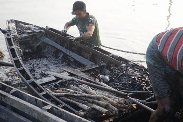 Locals land with a boat full of collected oil as well as branches coated in oil. The state-owned Padma Oil Company is paying locals for all the oil brought in. Photo by: Kallol Mustafa.