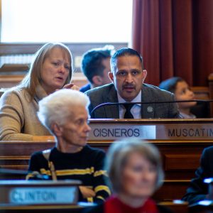 Rep. Mark Cisneros (R Muscatine) speaks with his aide as the session starts.