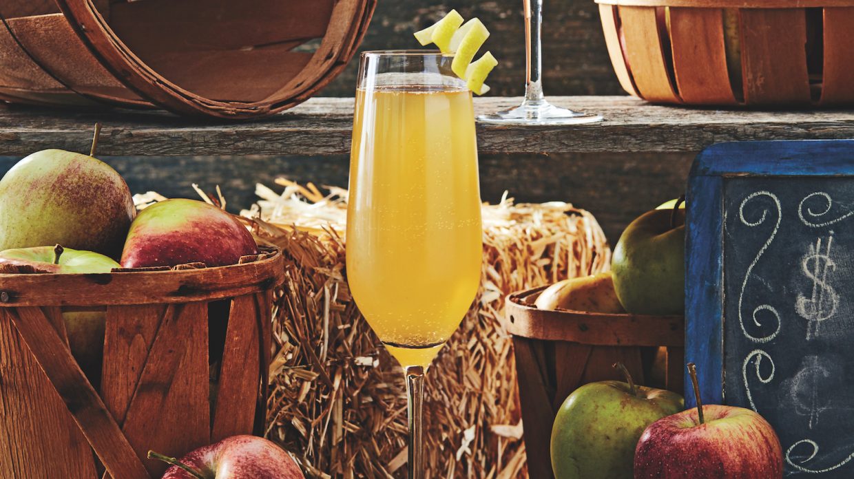 champagne flute with golden cocktail and lemon twist garnish