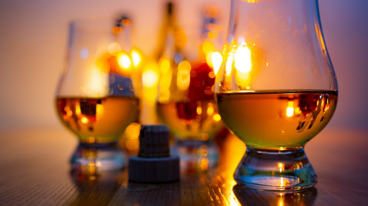 One Glencairn glass of whisky set apart from two others