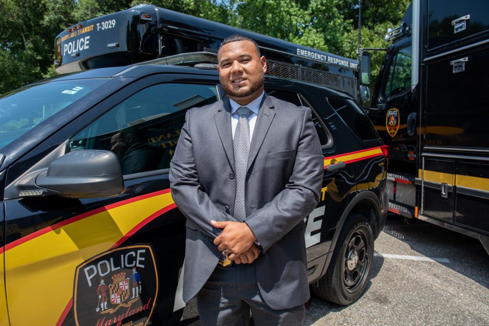 Photo of an MTA Police Detective standing next to a police vehicle