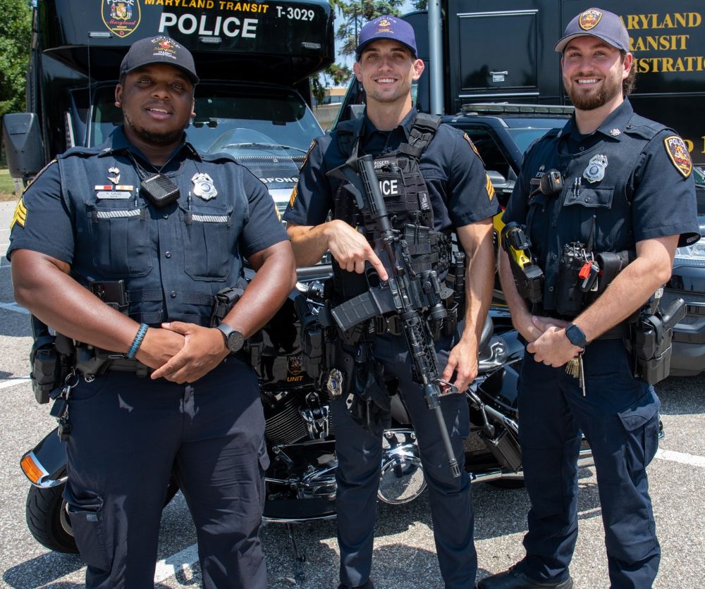 Photo of three MTA Police Officers standing next to a police vehicle